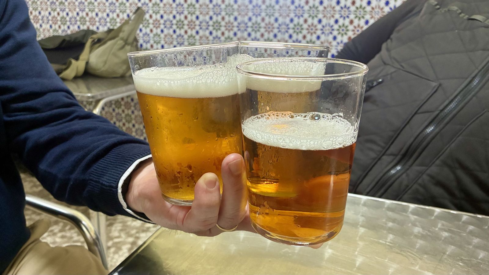 Tres cervezas en una mano.