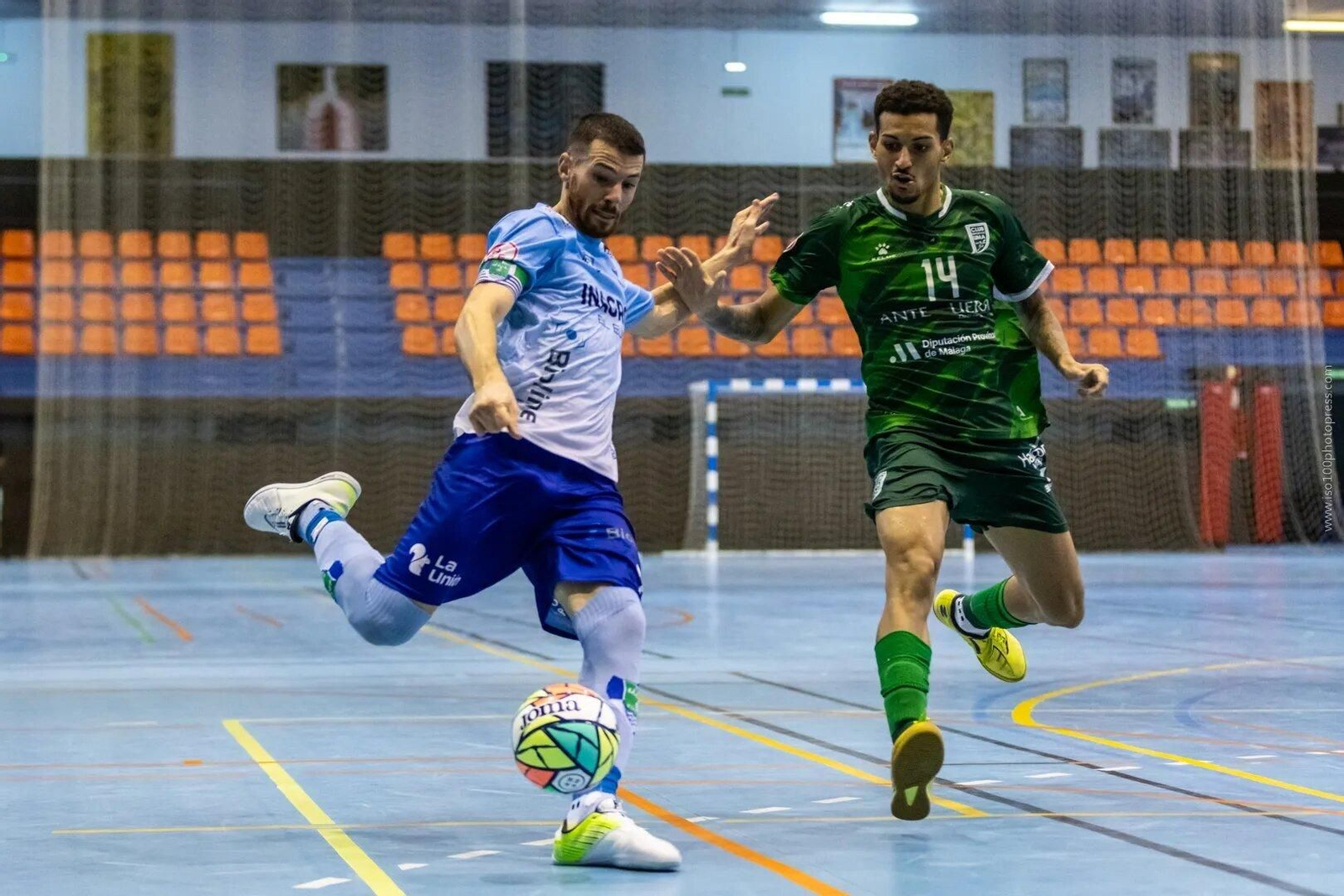 Un futbolista celeste realiza un disparo ante la oposición de un jugador del conjunto malagueño.