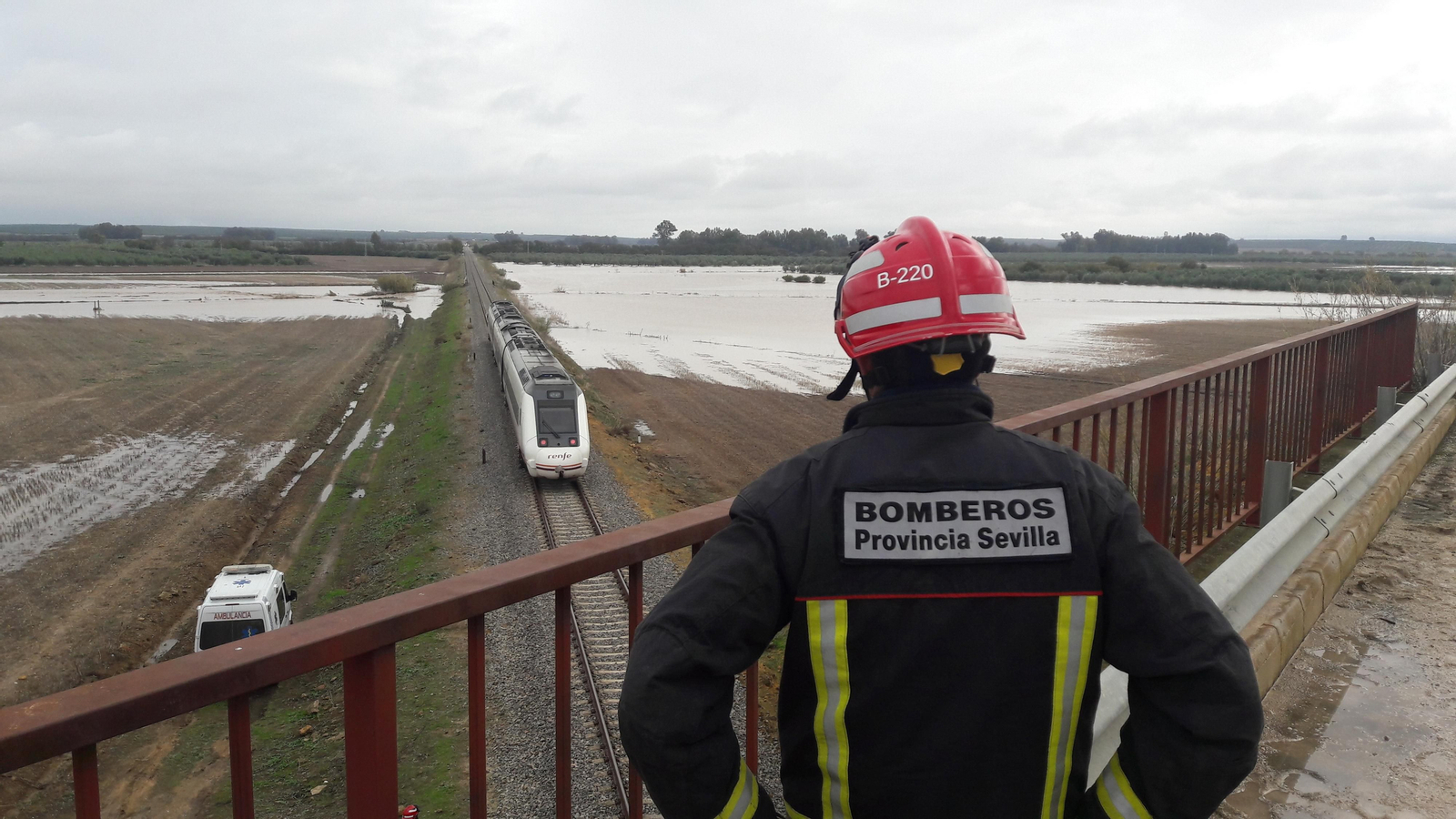 Un bombero mira el tren descarrilado desde un puente