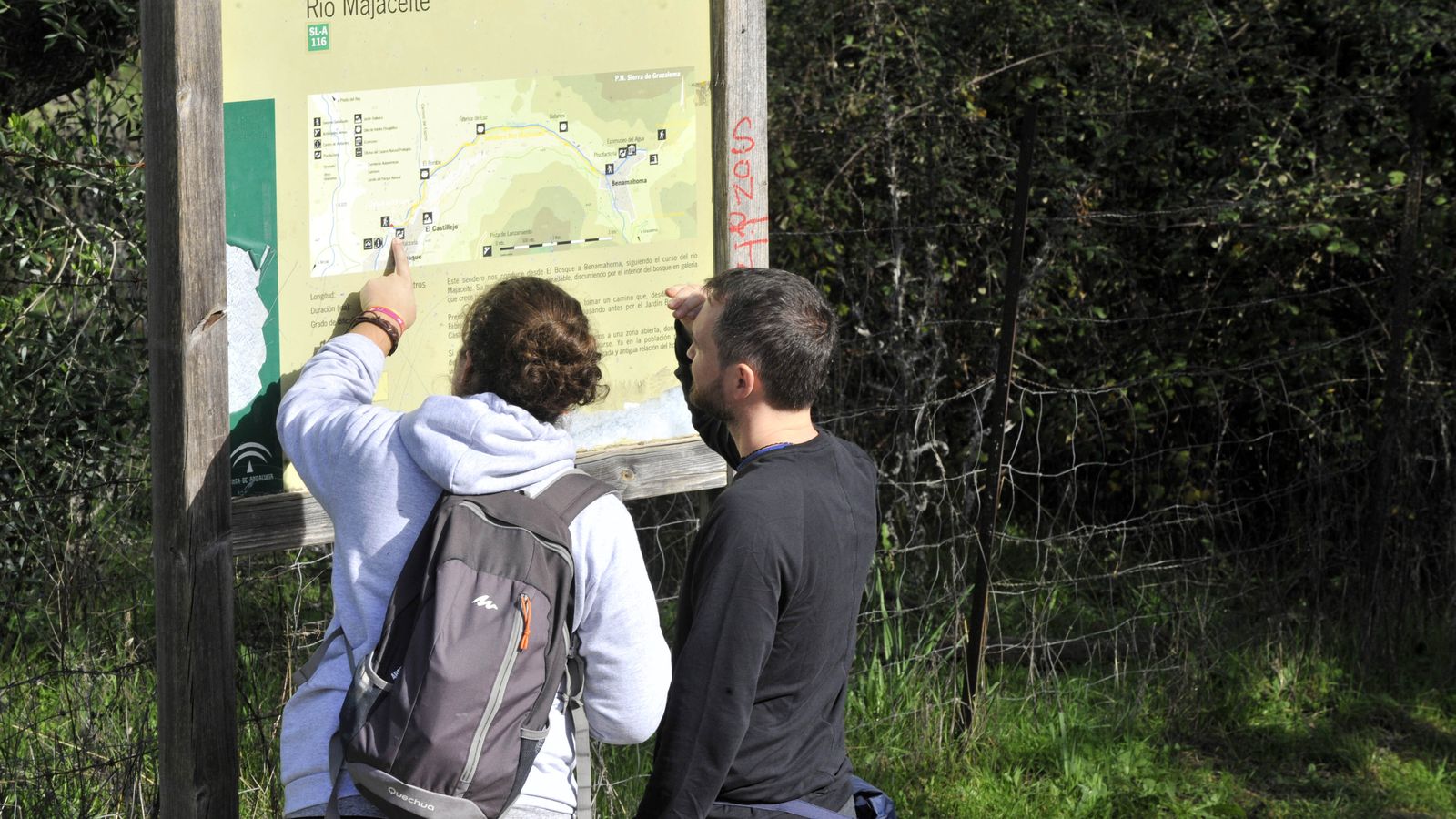 Senderistas consultando el panel informativo