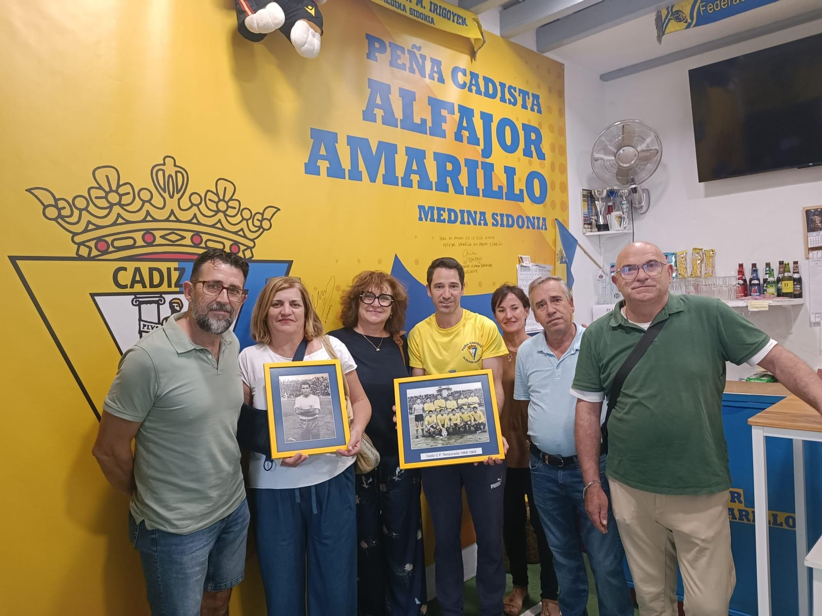 Alfonso Montero, presidente de la peña cadista, recibe la donación de manos de los hijos de Luis Aragón.