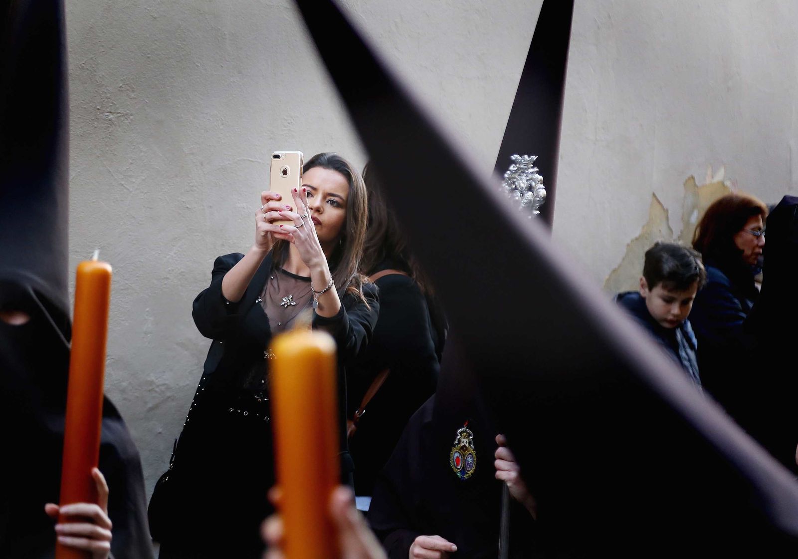 Una joven plasma ayer por la tarde con su móvil el discurrir de los penitentes de la Lanzada tras salir de la Basílica del Carmen.
