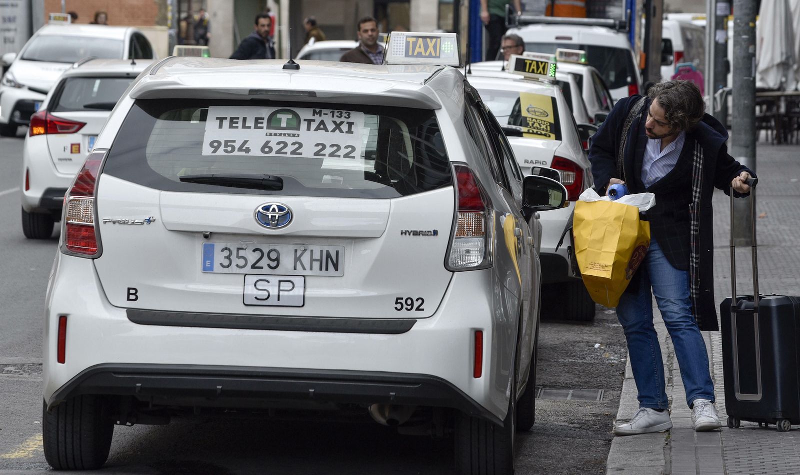 Un usuario pregunta por un servicio a un taxista en Sevilla.