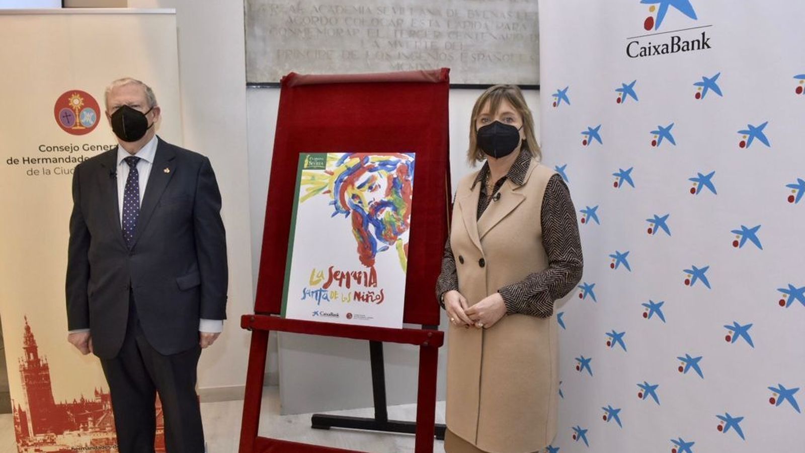 Francisco Vélez y María Jesús Catalá junto al cartel de La Semana Santa de los Niños.