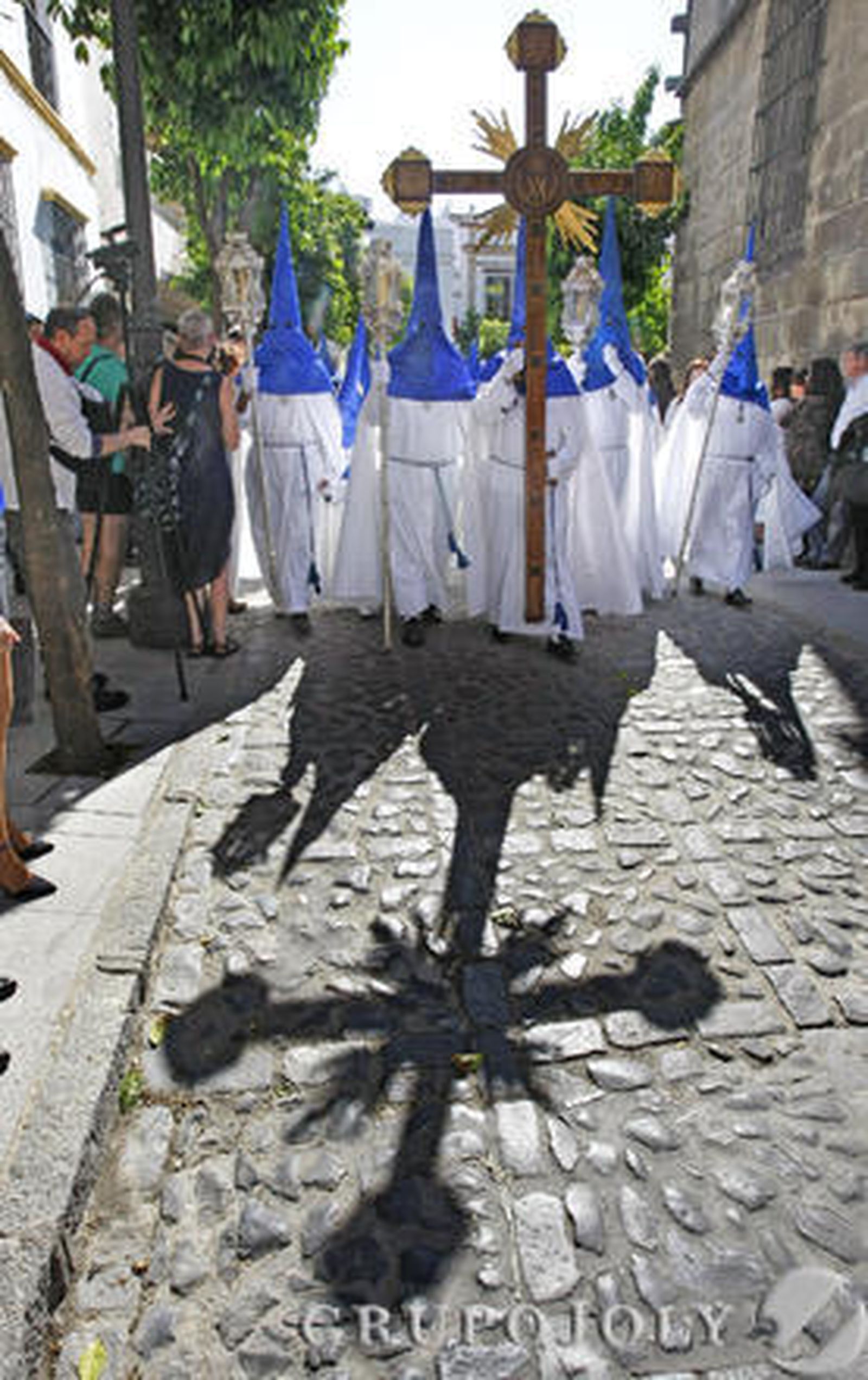 El brillante sol de la tarde proyecta la cruz de guía en el adoquinado.

Foto: Pascual
