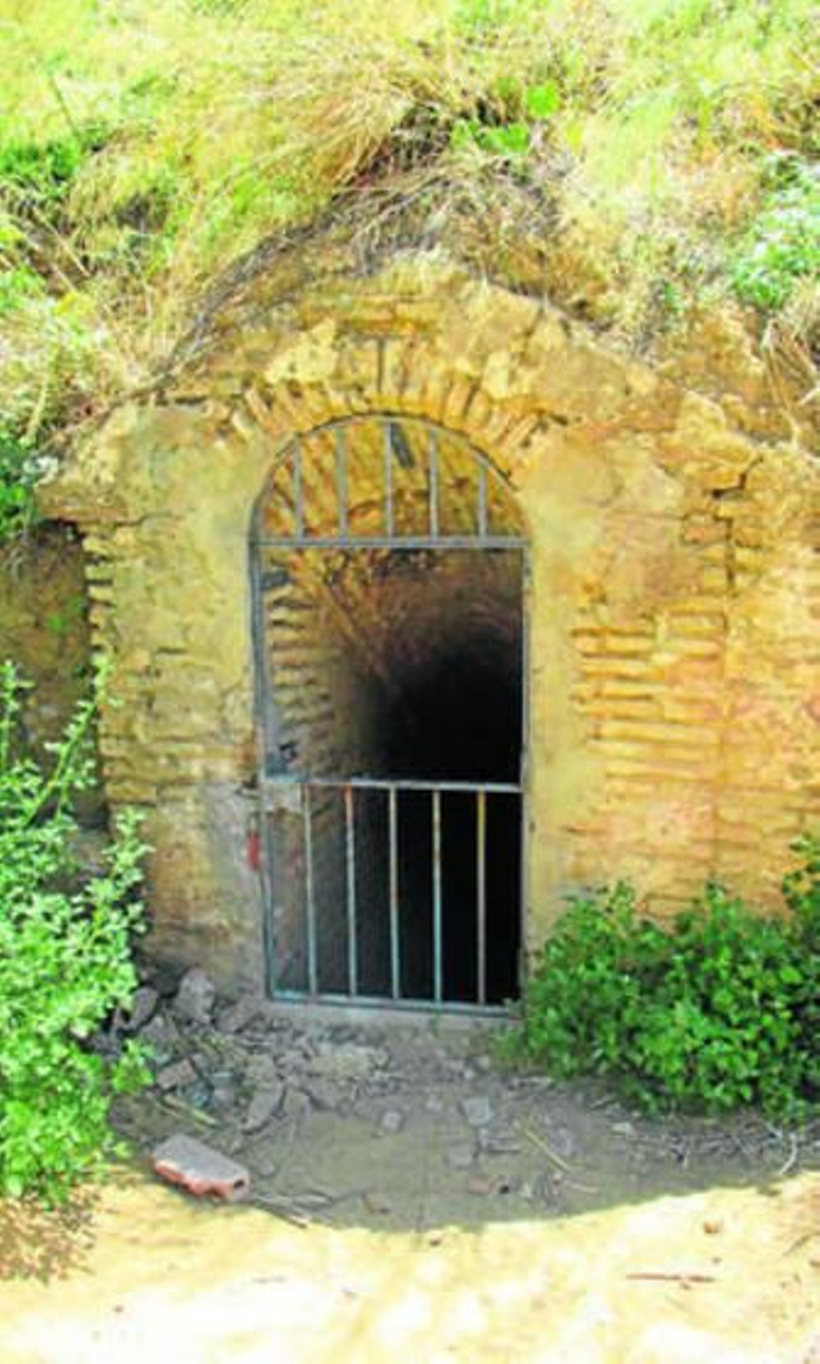 1. Puerta de acceso al acueducto romano en la ladera del cabezo de la trasera de la calle Pintor Pedro Gómez. 2. Túnel que conduce hasta la boca de un pozo. 3. Junto a los agarres en la bóveda de la puerta se ve una gran grieta. 4. Detalle en que se aprecia que no faltan barrotes. 5. Un aliviadero del que están desprendidos algunos ladrillos.