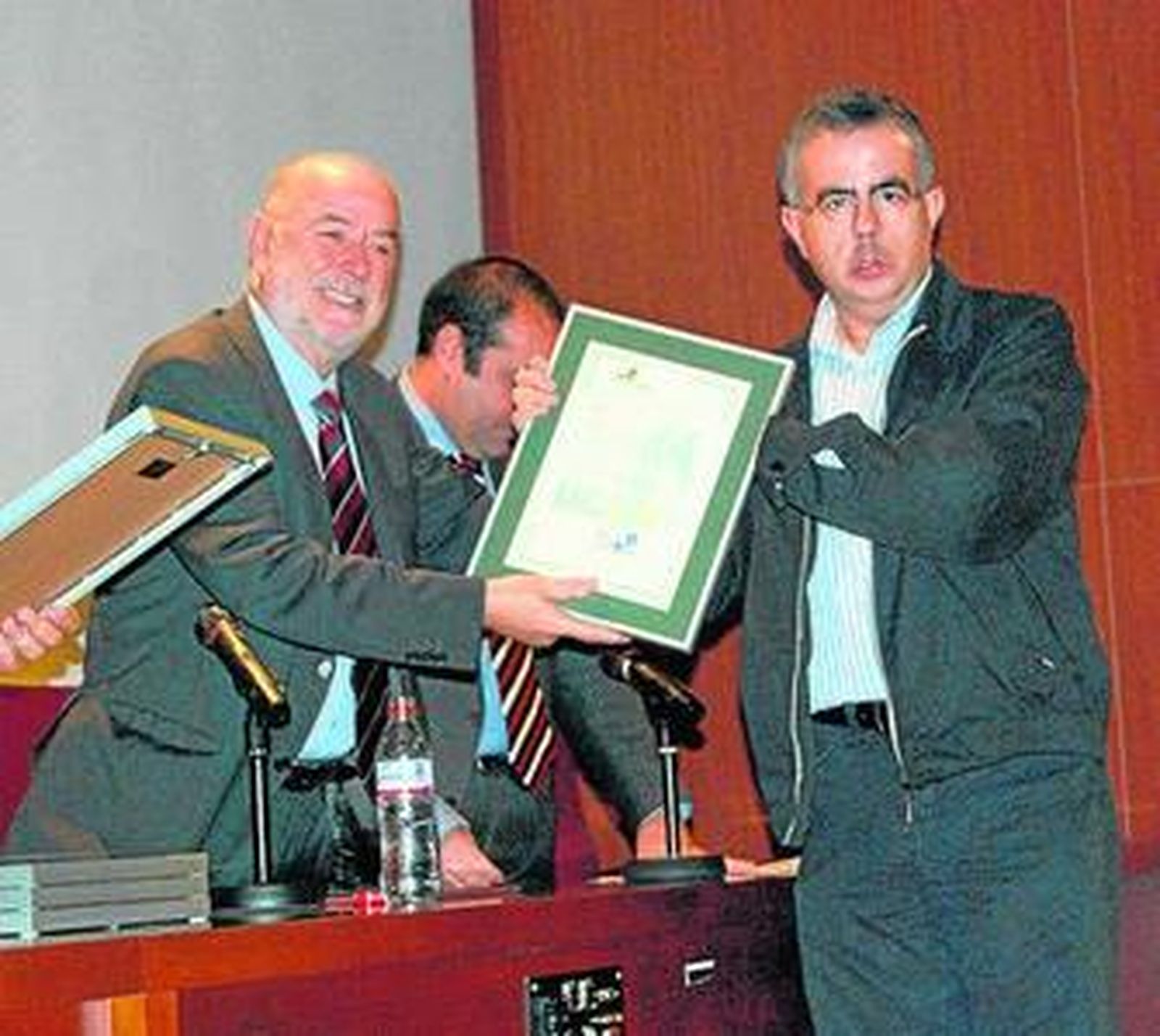 El rector entrega uno de los reconocimientos.