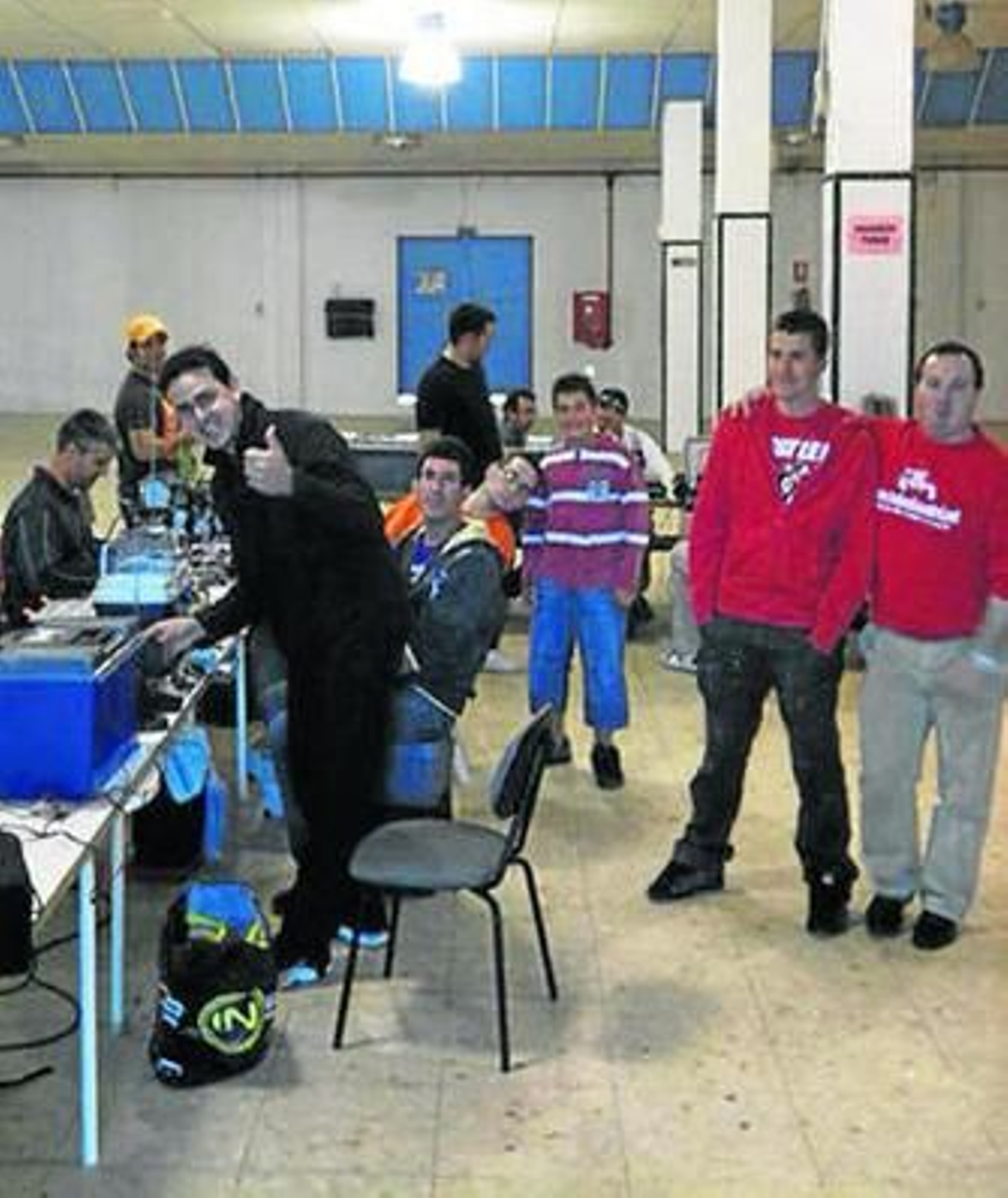 Los pilotos de radiocontrol Mini-Z preparan sus coches en boxes.