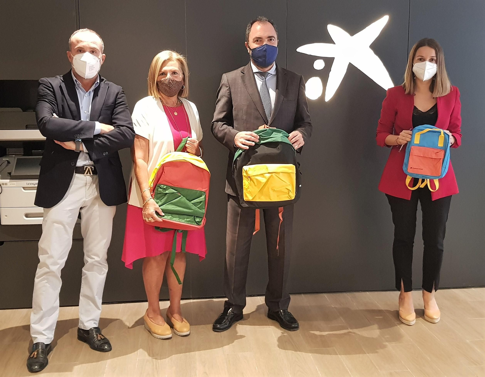 La entrega de los kits escolares a la concejala Carmen Lara por parte de los responsables de La Caixa.