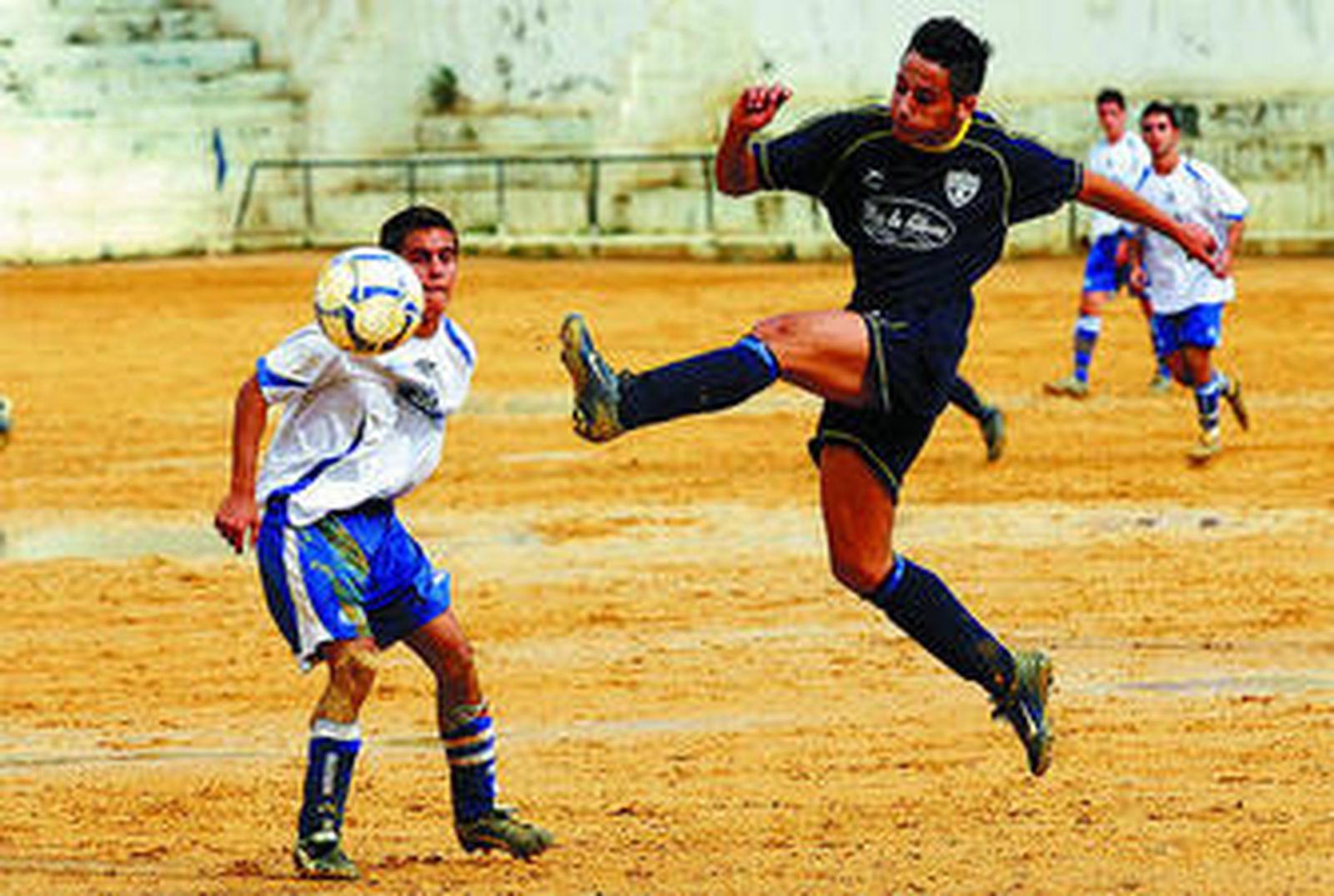 Un jugador del Puerto golpea el balón ante un rival de Las Lagunas.