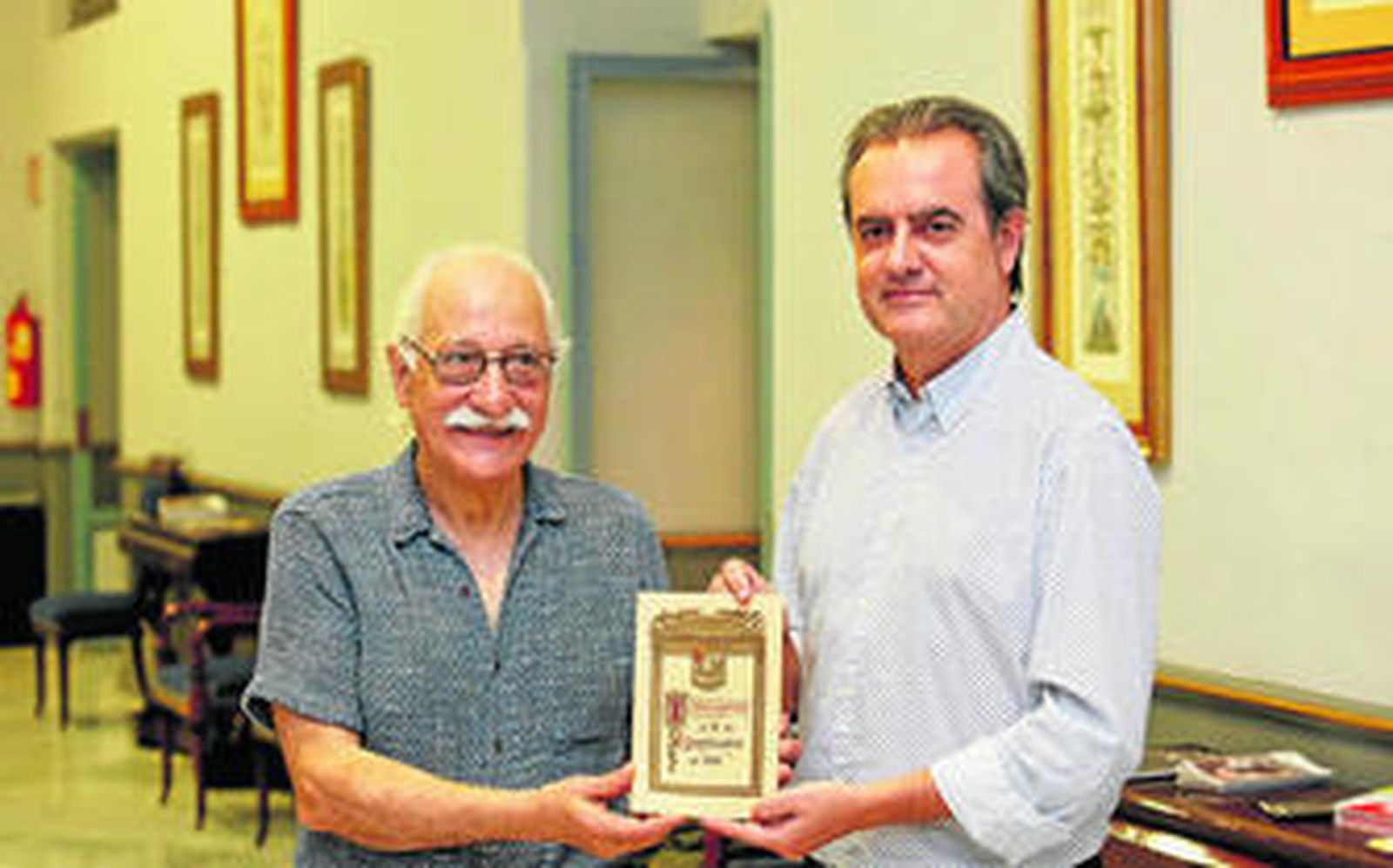 Rubens Correa y Juan Antonio Vigar mostrando el programa inaugural del Teatro Nacional Cervantes (de 1921)