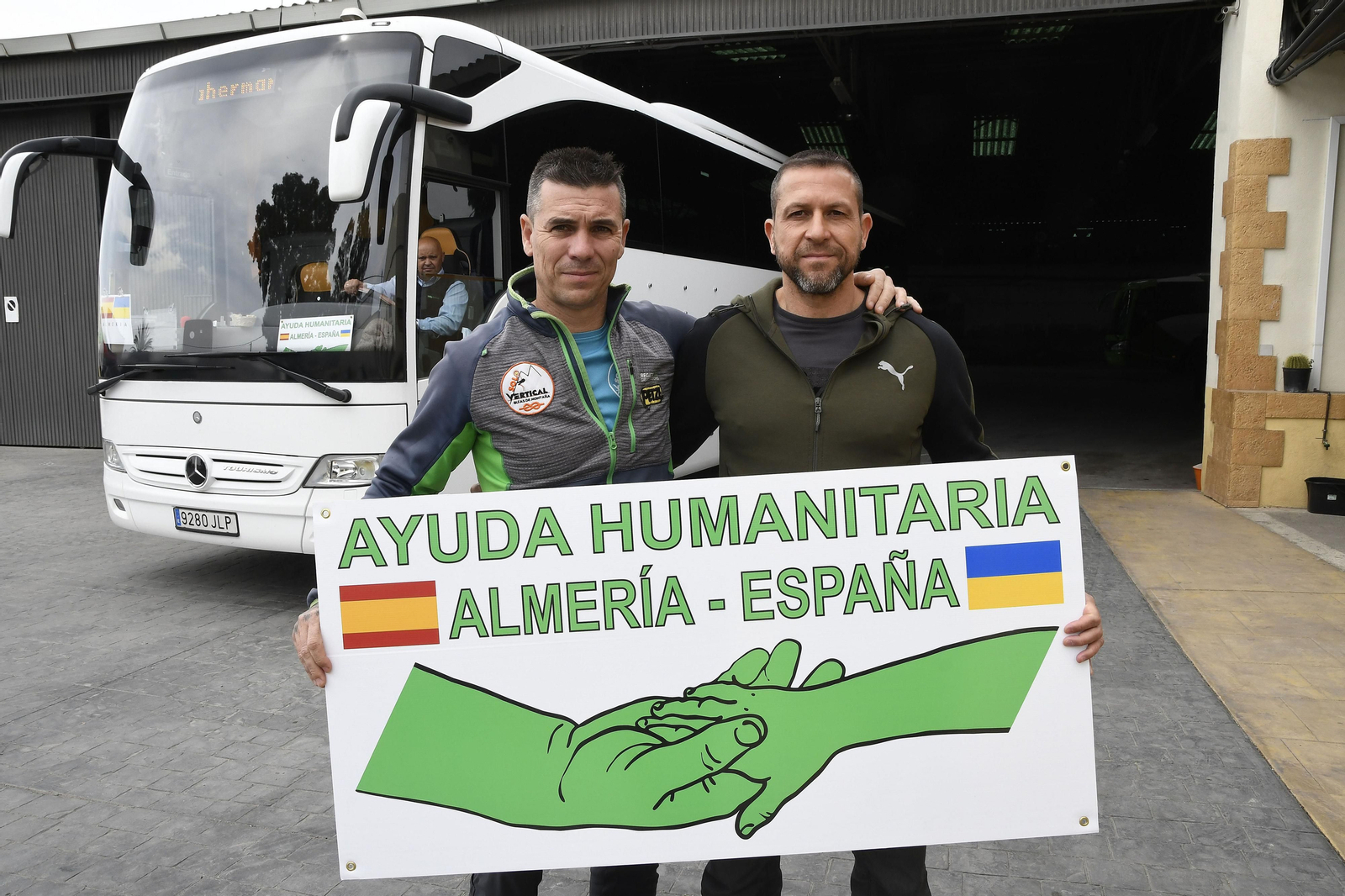 David González y Ramón Ortiz con un cartel de su proyecto de ayuda humanitaria