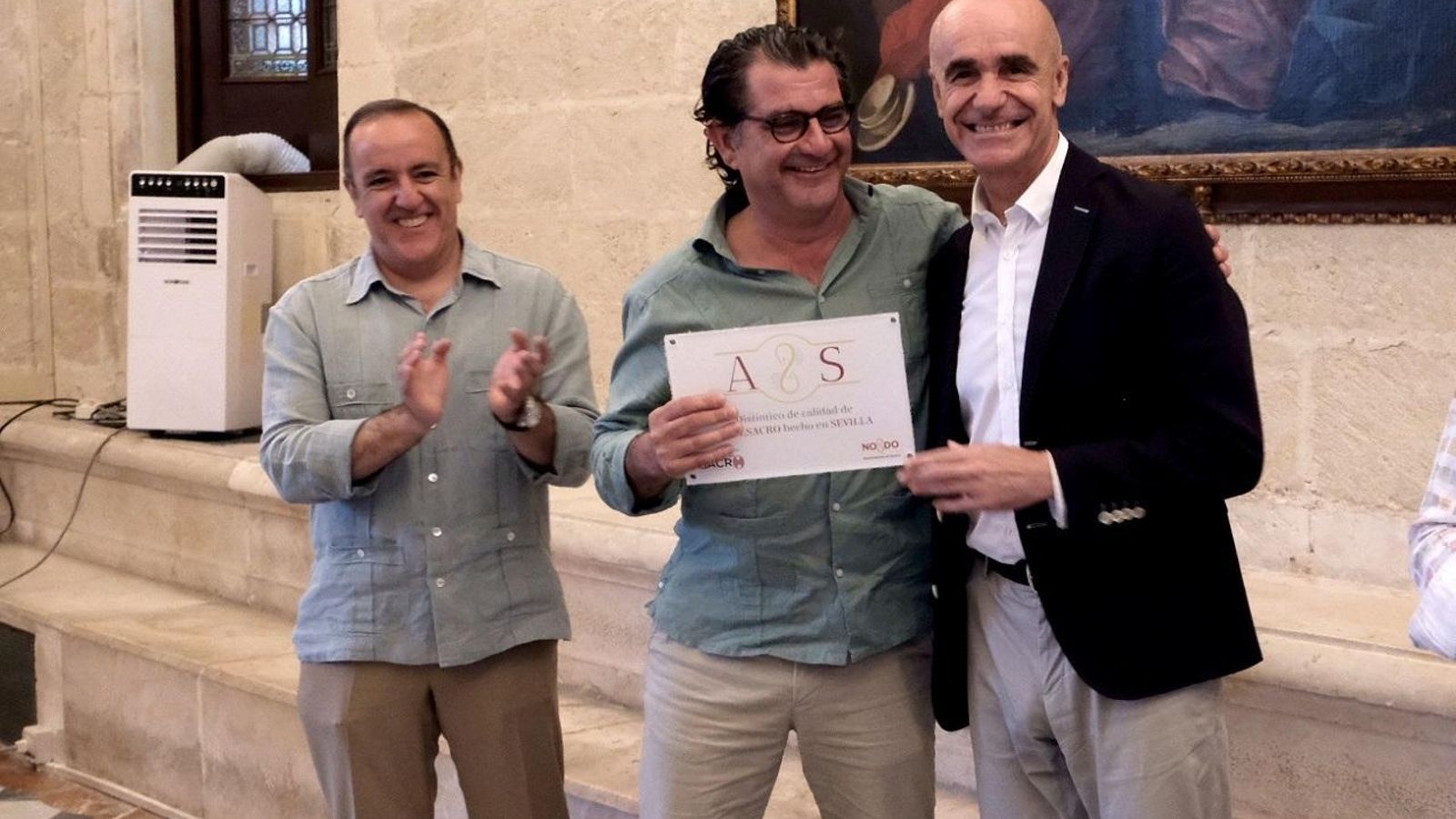 El alcalde entrega uno de los sellos de excelencia.