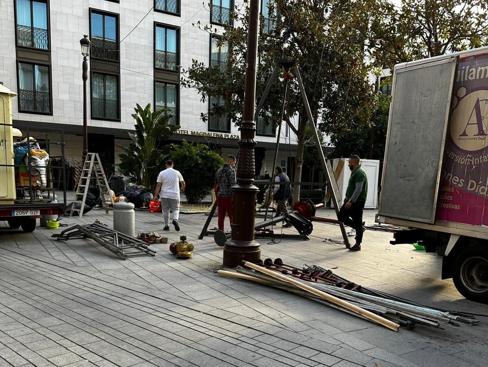 Varios operarios instalando las atracciones infantiles en la Plaza de la Magdalena.