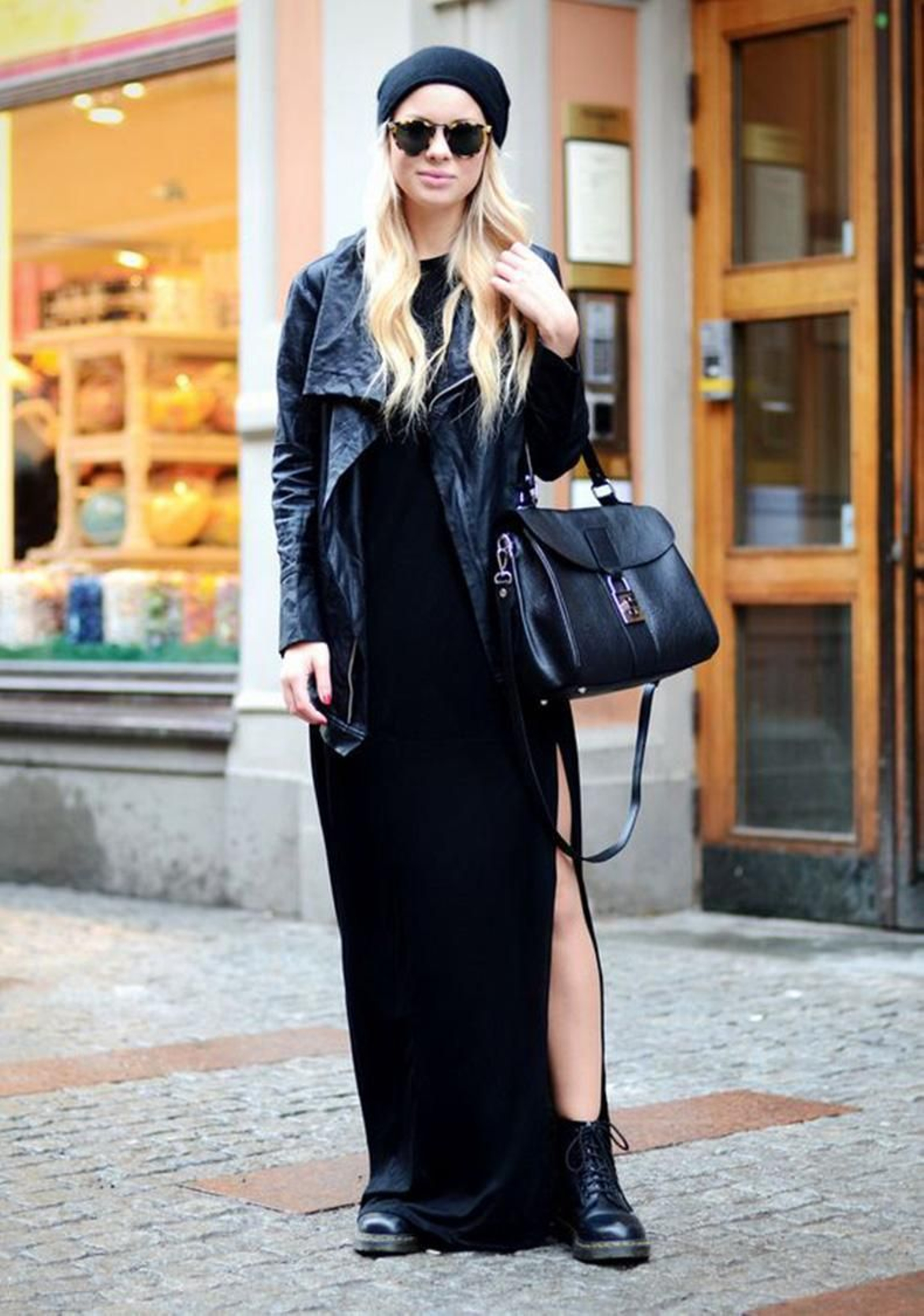 Look con vestido negro largo, botas de cordones, biker y gorro.