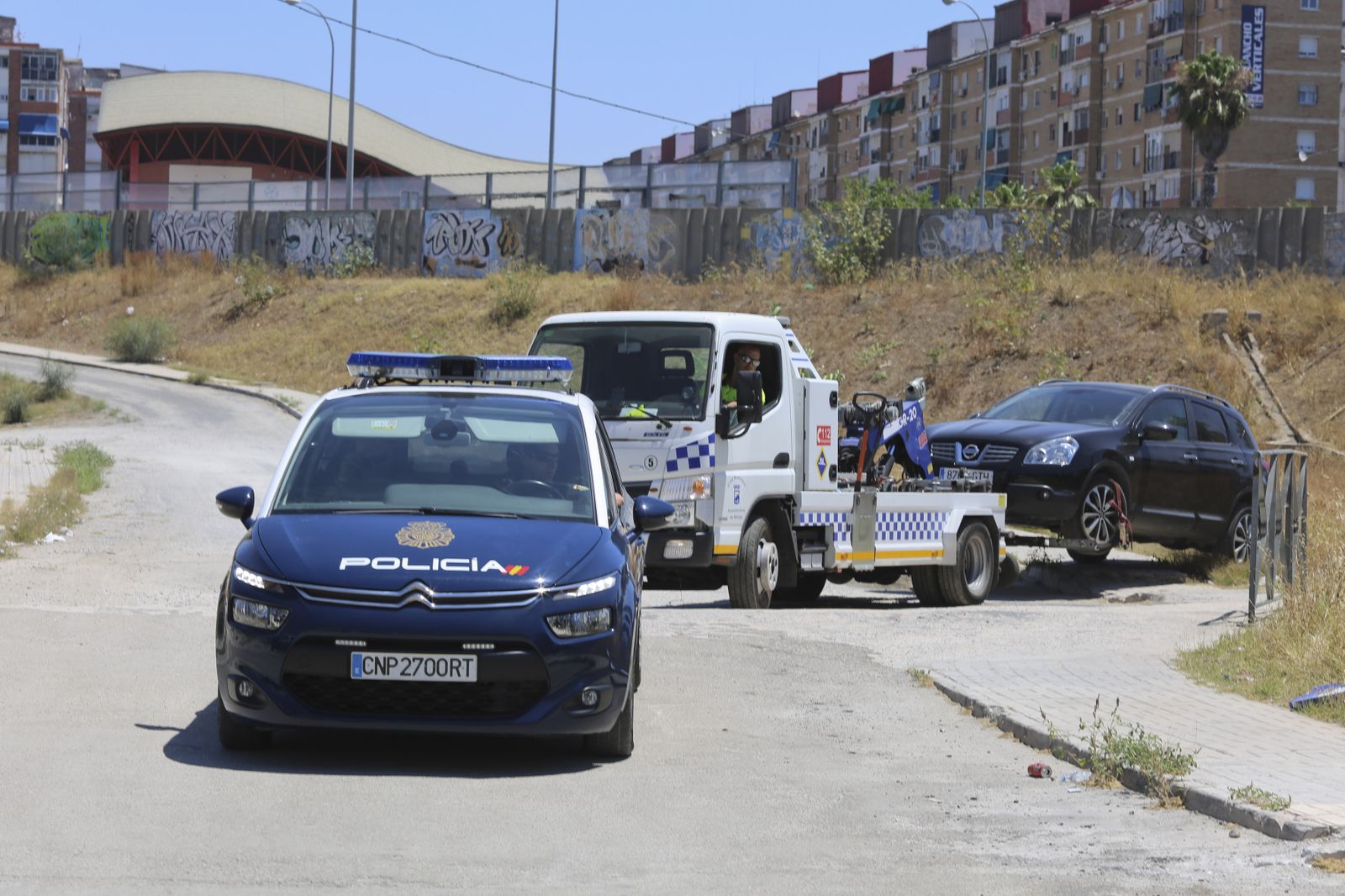 Una grúa retira el vehículo en el que se encontró el cuerpo sin vida del presunto agresor.