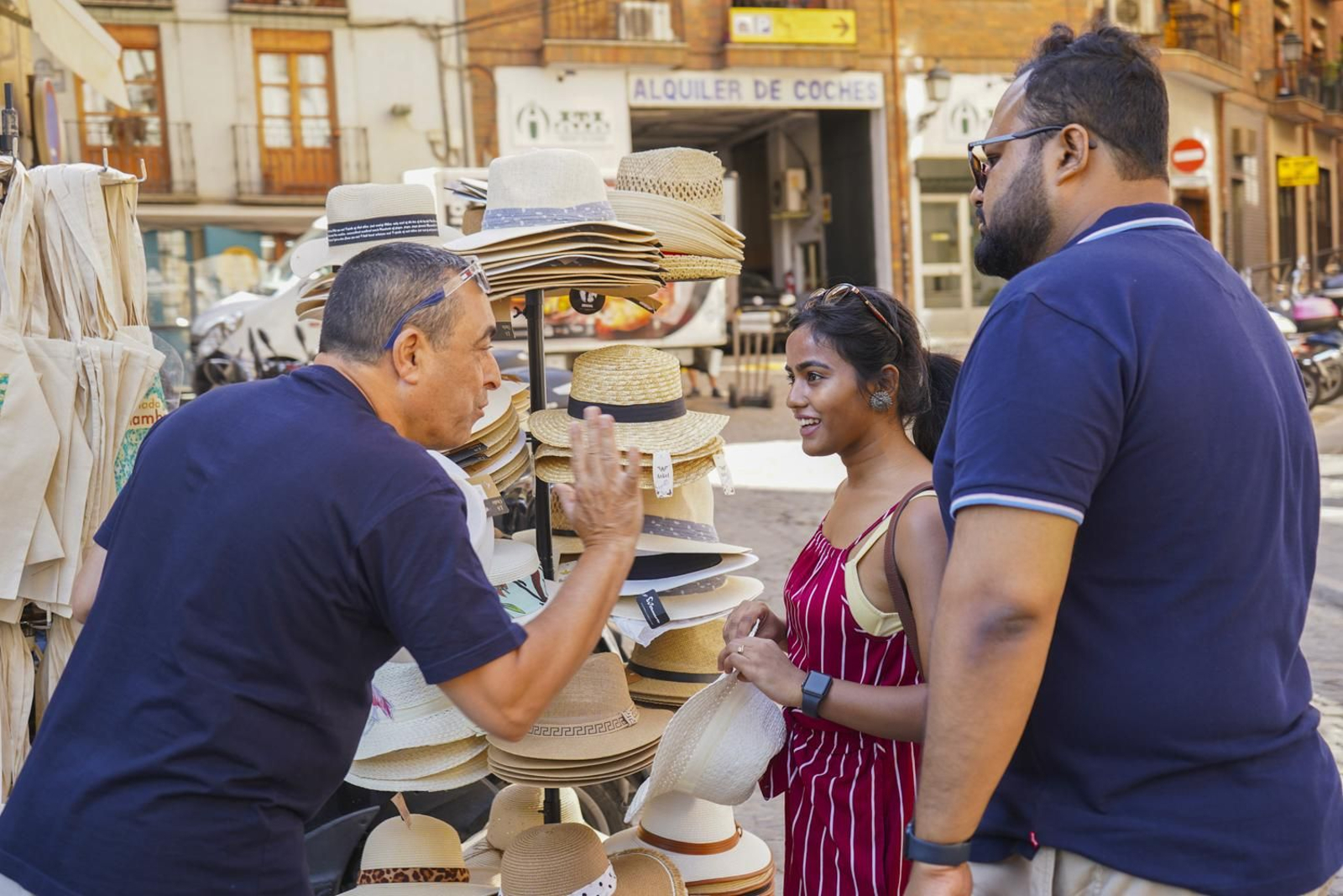 Dos turistas conversan con un vendedor en el centro de Granada.