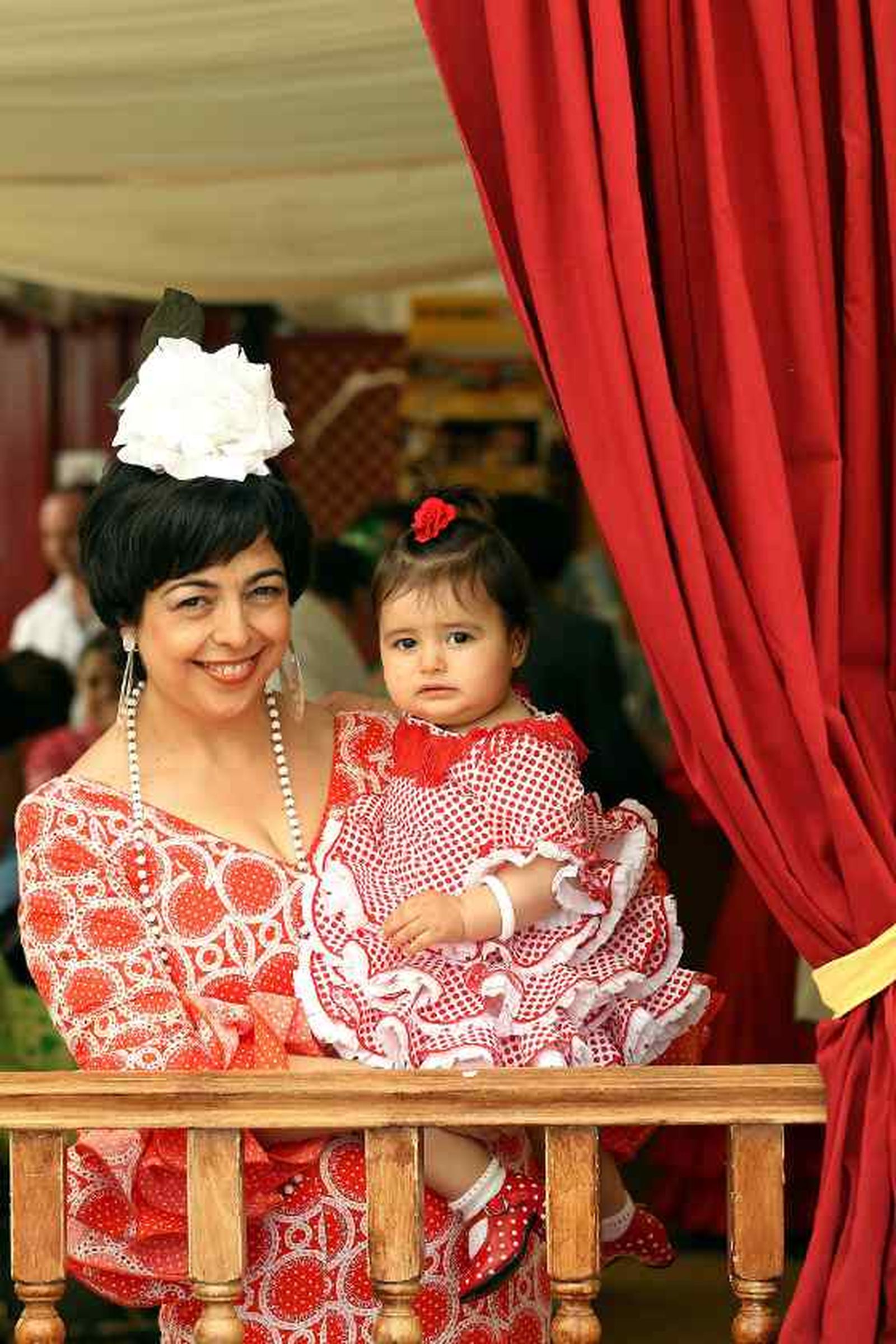 Inma y su hija María contemplan la belleza de la Feria asomadas entre las cortinas de caseta

Foto: M.A. González- Pascual