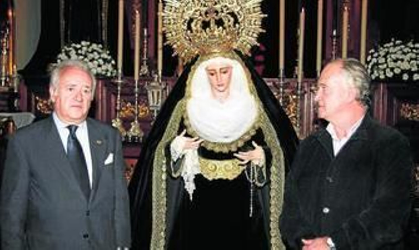 El hermano mayor, Vicente Camacho, y el restaurador, Luis Álvarez Duarte, junto a la Virgen.