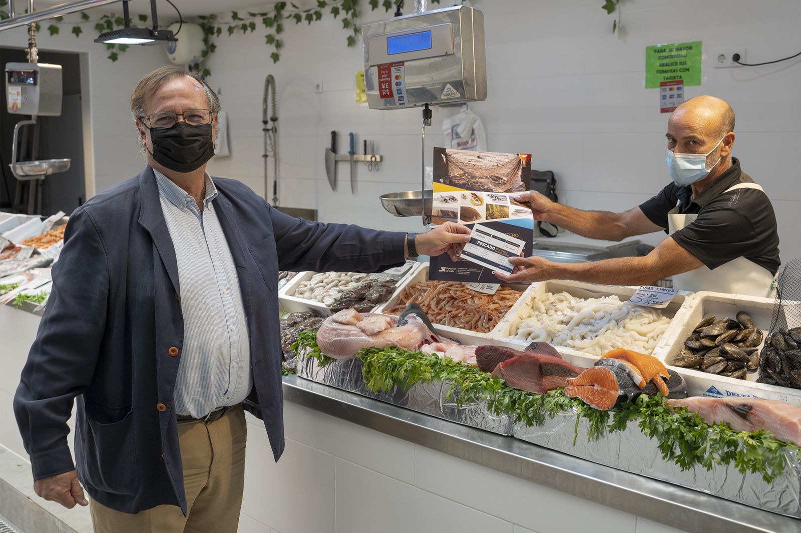 García de Lomas entrega el material sobre el Pescado de Estero tradicional a un pescadero.