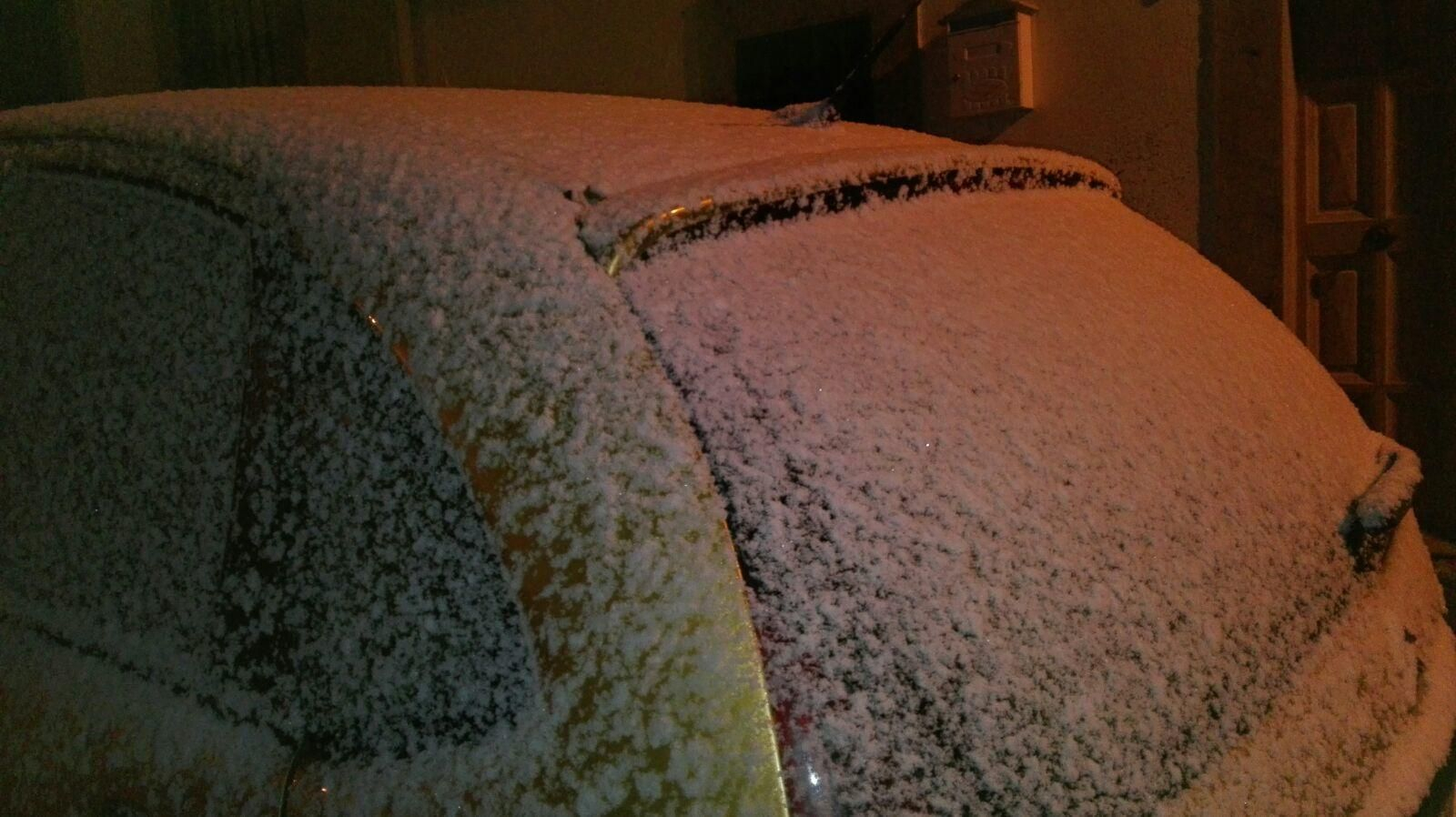La nieve cubre un automóvil en una calle de  Cardeña.
