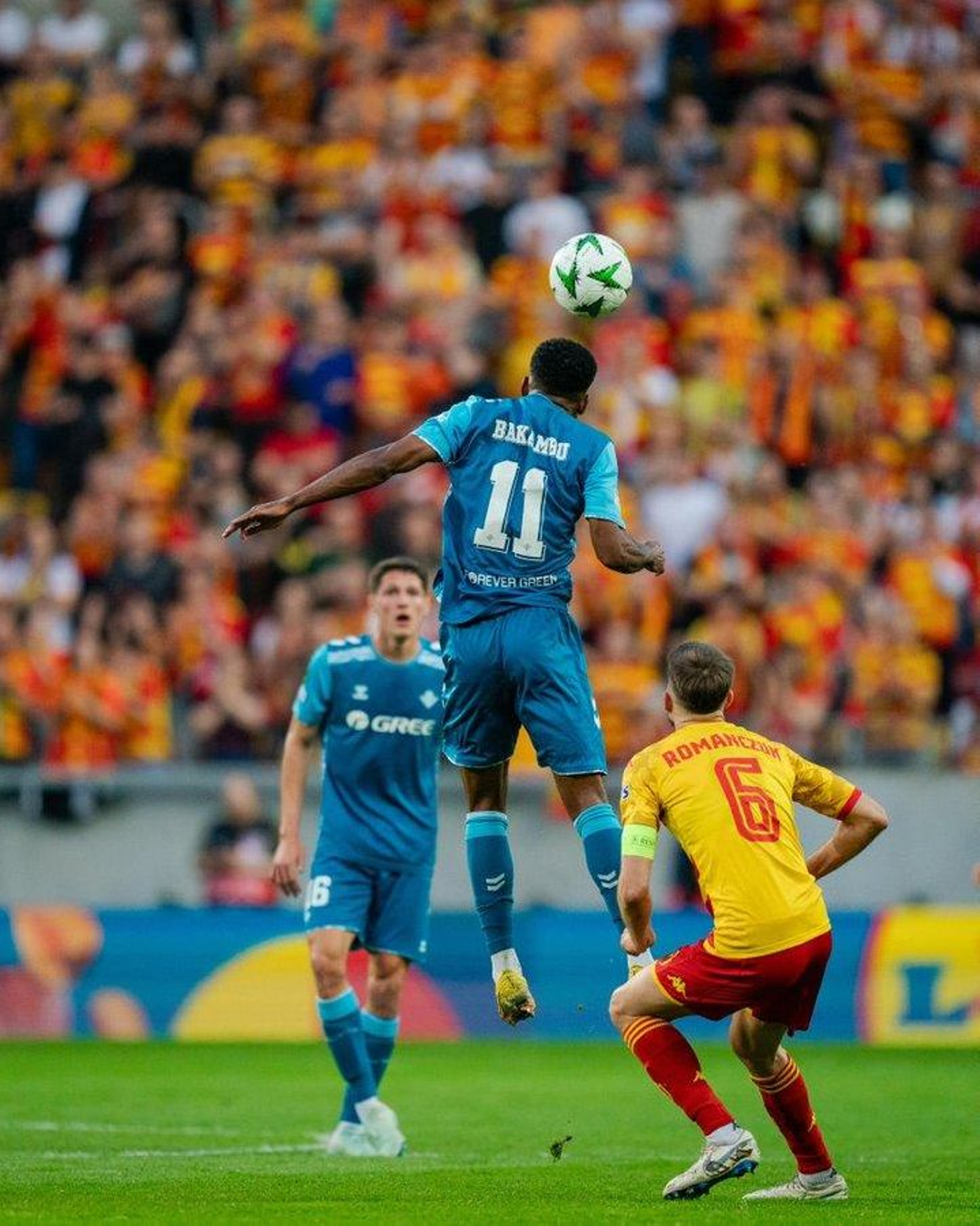 Bakambu salta muy arriba para tocar el balón de cabeza ante Romanczuk.