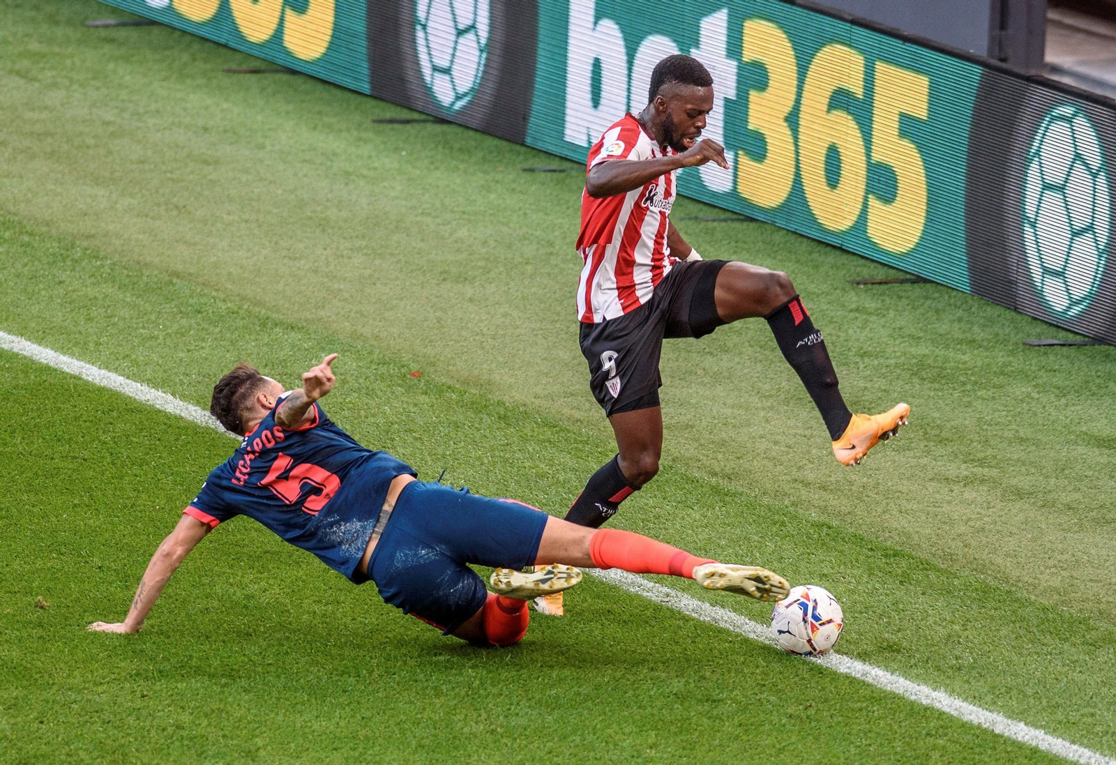 Williams trata de superar a Ocampos, que se tira a ras del suelo.