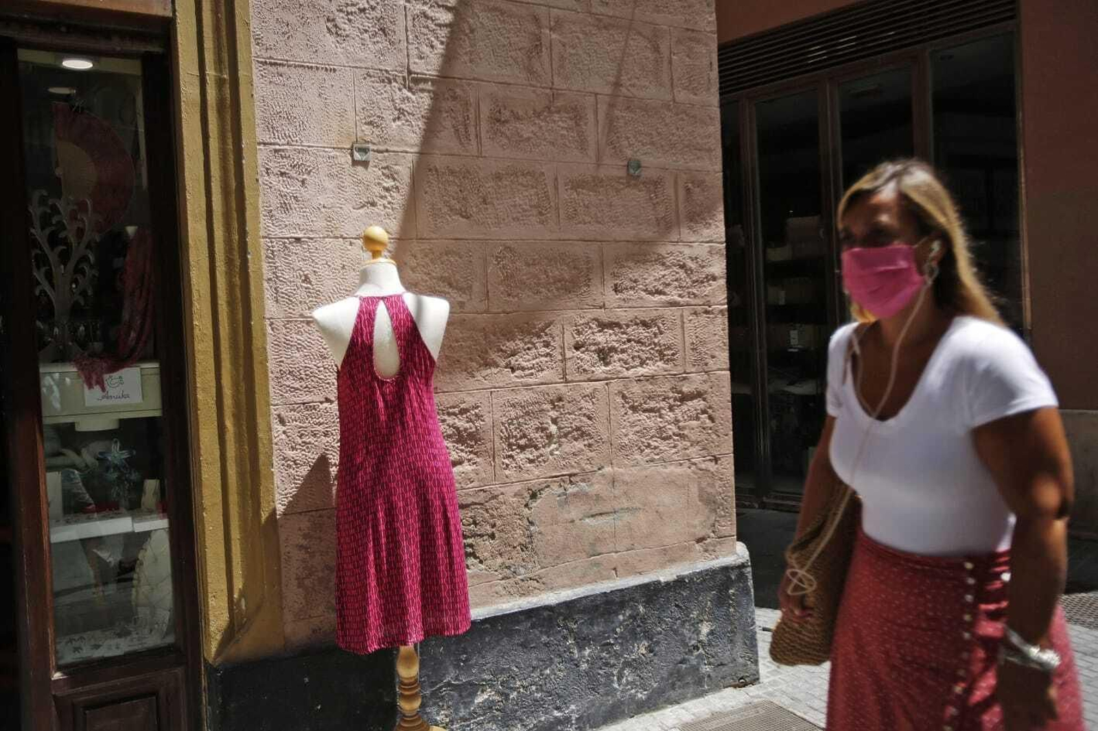 Una mujer con su mascarilla paseando por Cádiz.