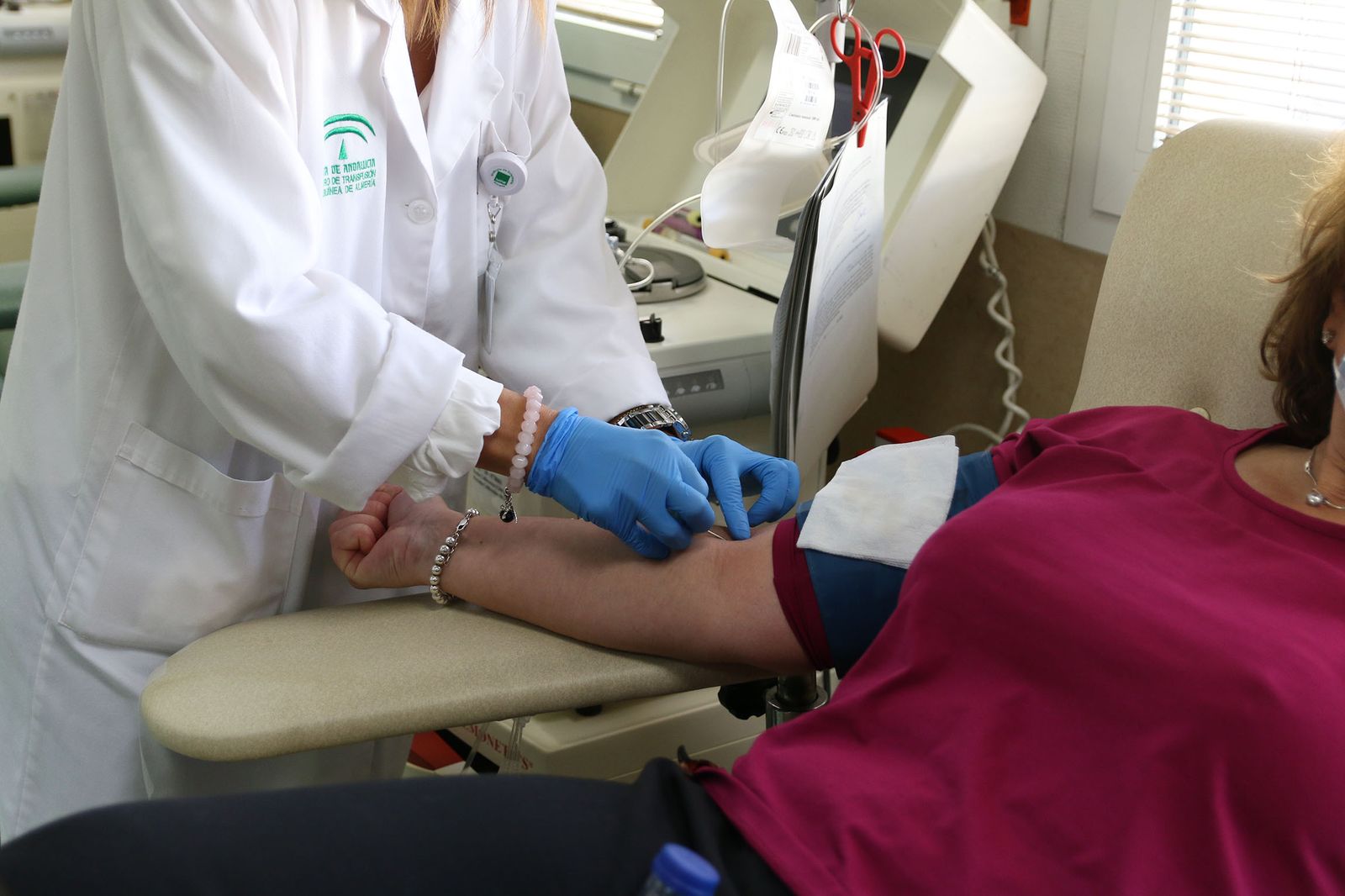 Una enfermera coge una vía a una mujer para donar sangre.