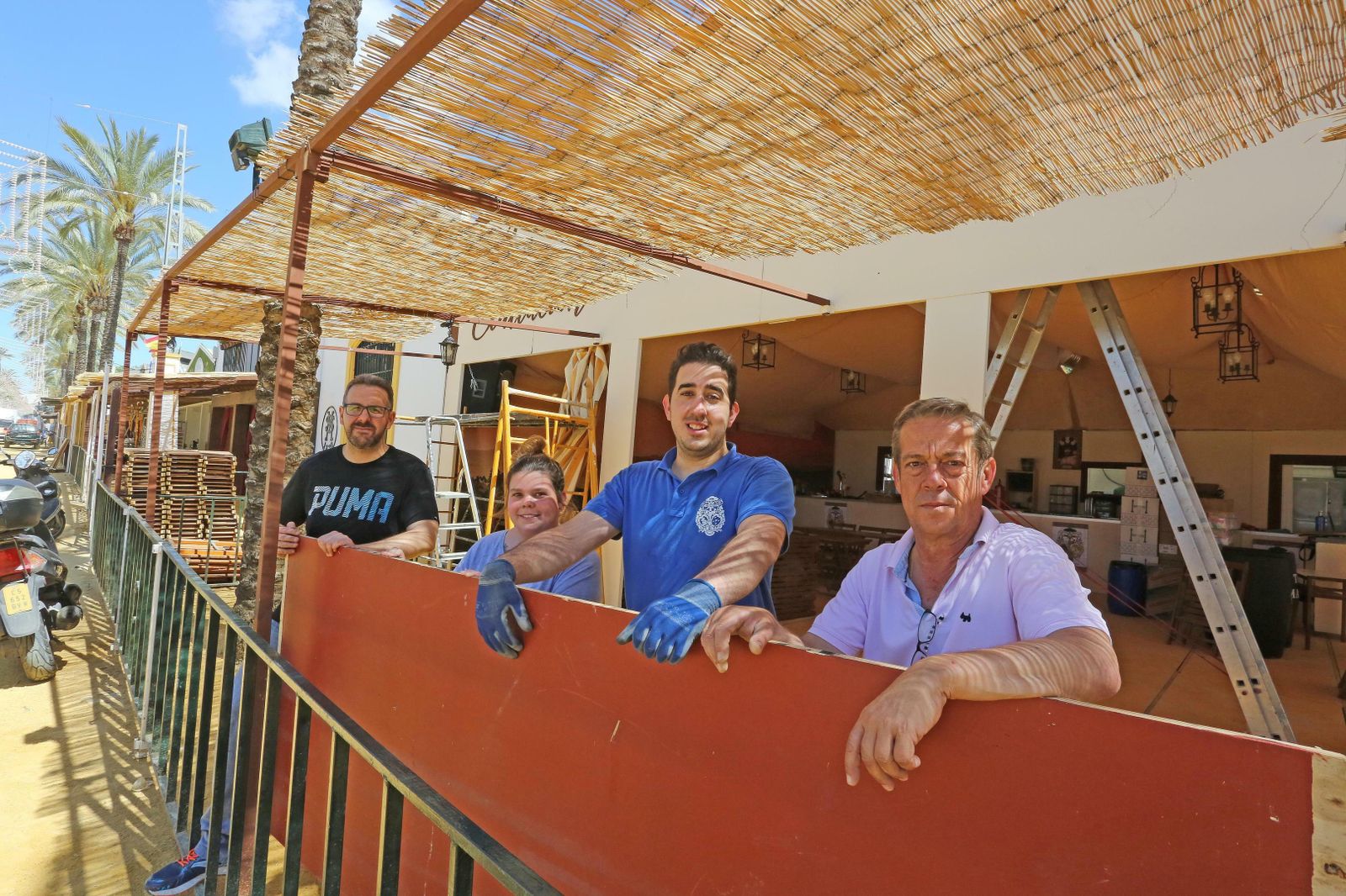 Un grupo de cofrades de la Exaltación montando su caseta de Feria.