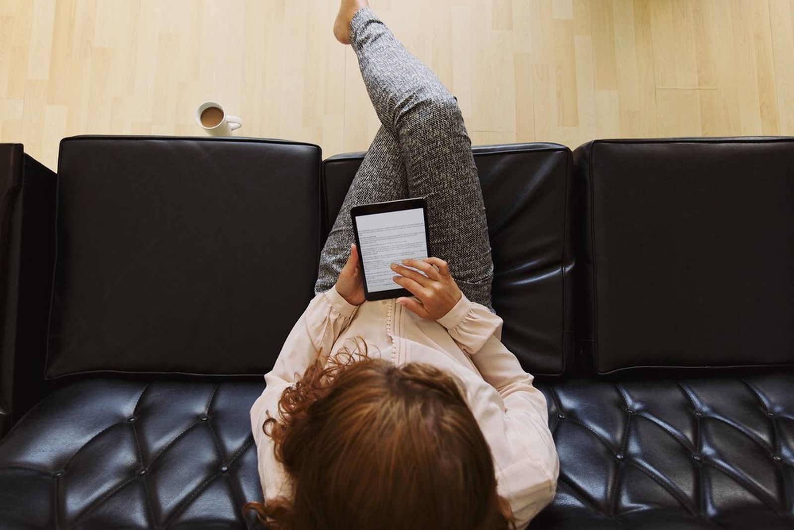 Una mujer lee en un dispositivo electrónico.
