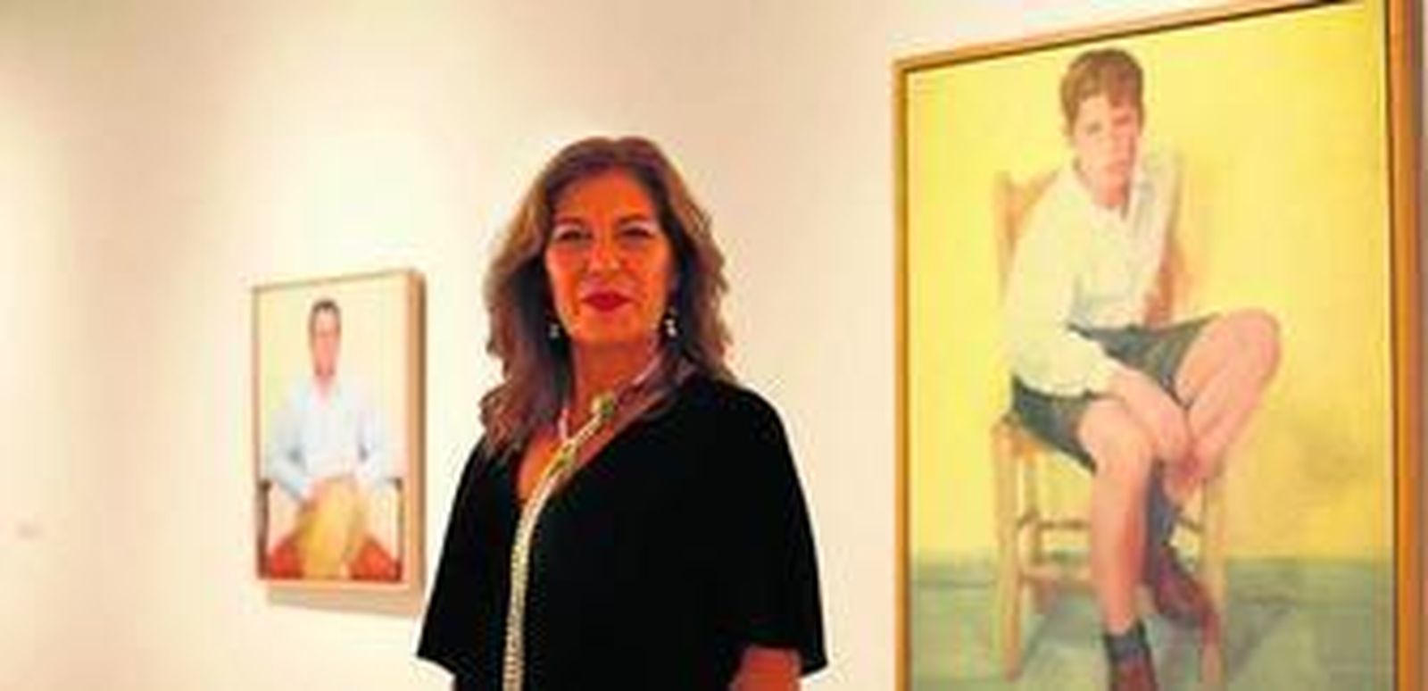 La pintora sevillana Reyes de la Lastra, ante algunos de los cuadros de su exposición en la Fundación Cajasol.