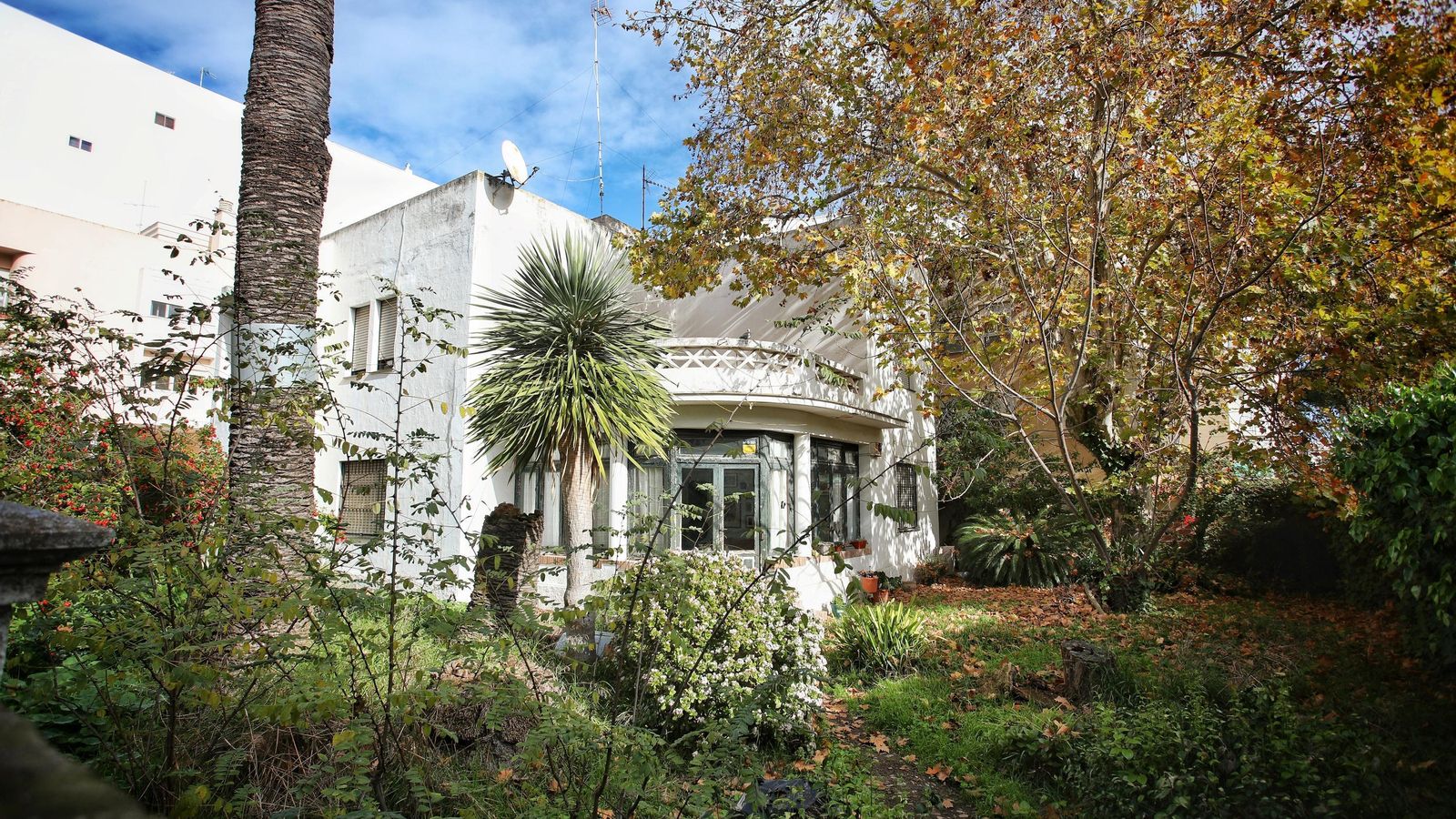 El porche cerrado y el amplio jardín de la finca antes de su derribo
