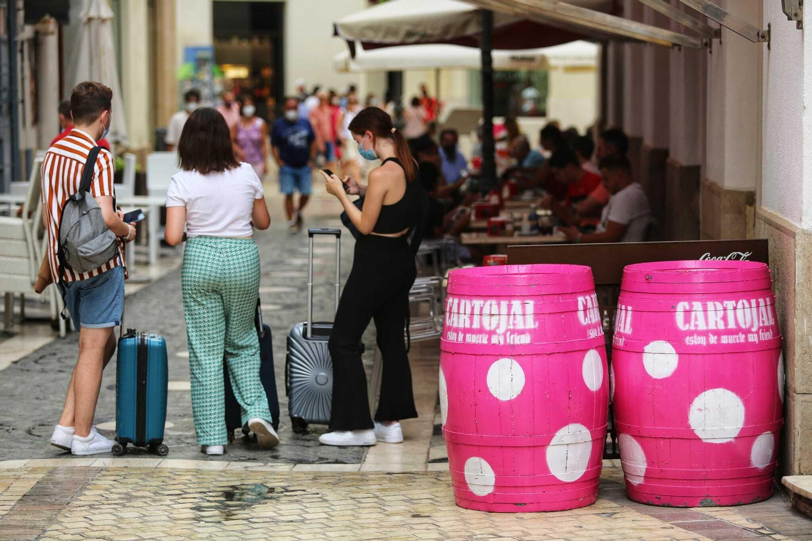 Tres jóvenes turistas con maletas este miércoles en una calle del Centro histórico de Málaga.