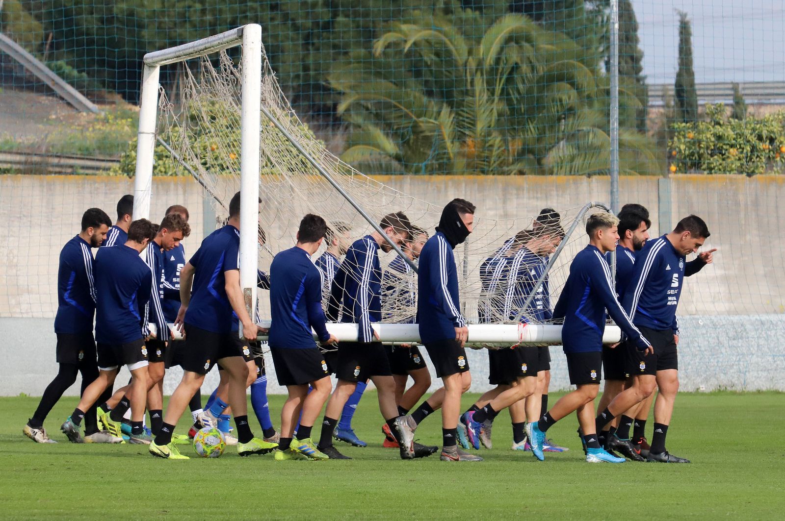 Varios futbolistas del Recre trasladan una portería en un entrenamiento reciente.