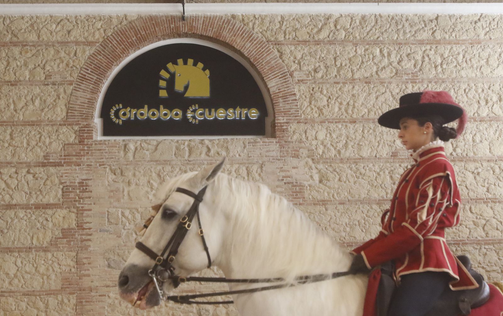 Una amazona pasa junto al logo de Córdoba Ecuestre.