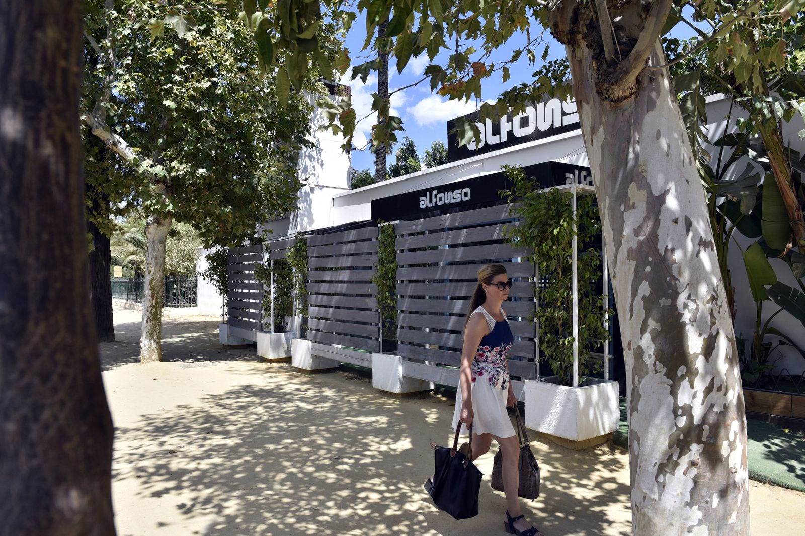 Una mujer pasa por la puerta de Alfonso.
