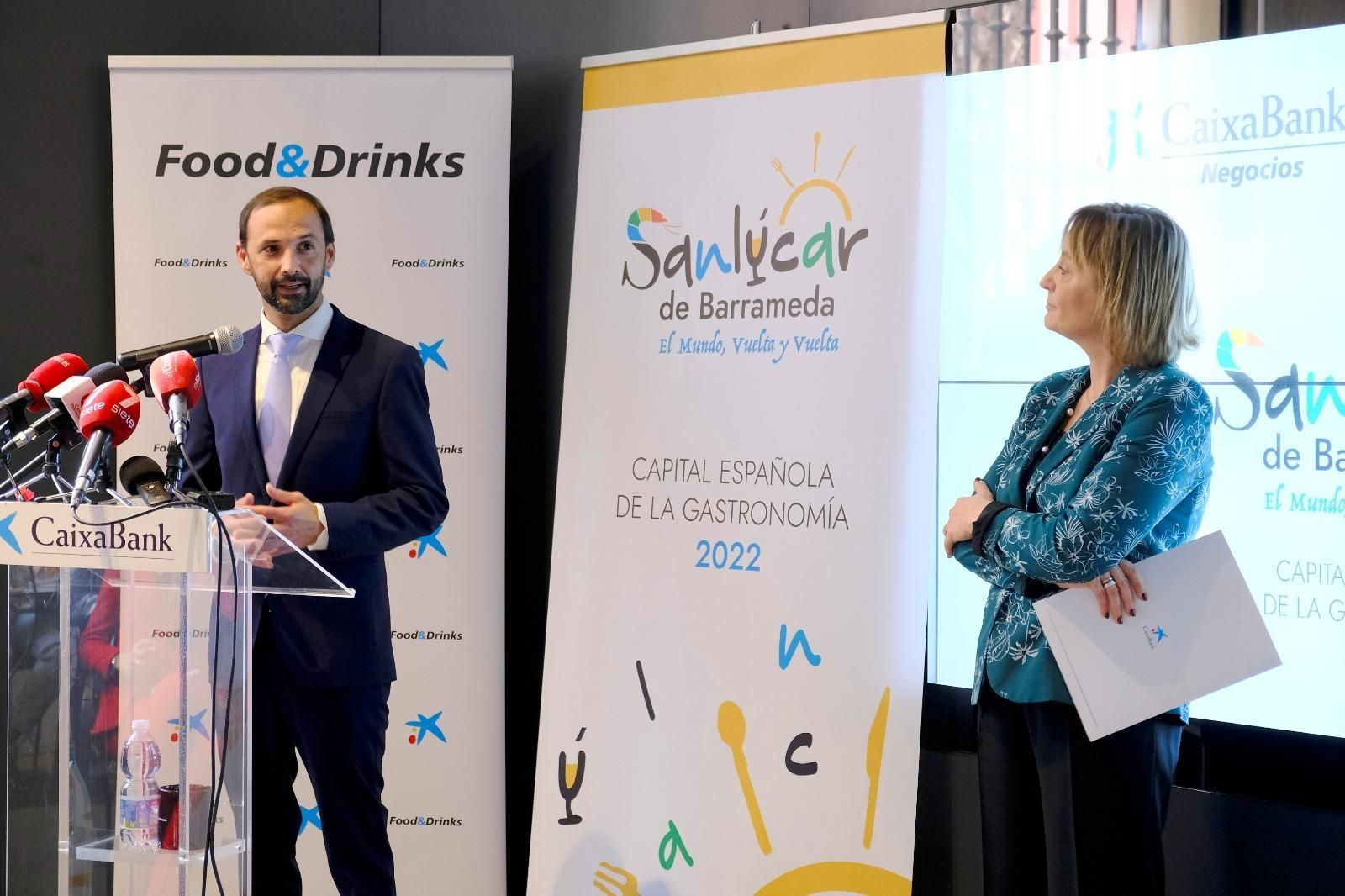 El alcalde de Sanlúcar, Víctor Mora, y la directora de CaixaBank en Andalucía Occidental y Extremadura, María Jesús Catalá, presentando en Sevilla el programa de actos.