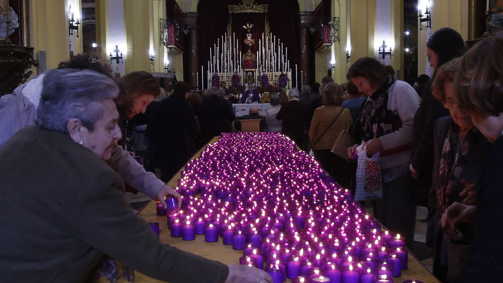 Los devotos llevan velas al Cautivo de San Ildefonso.