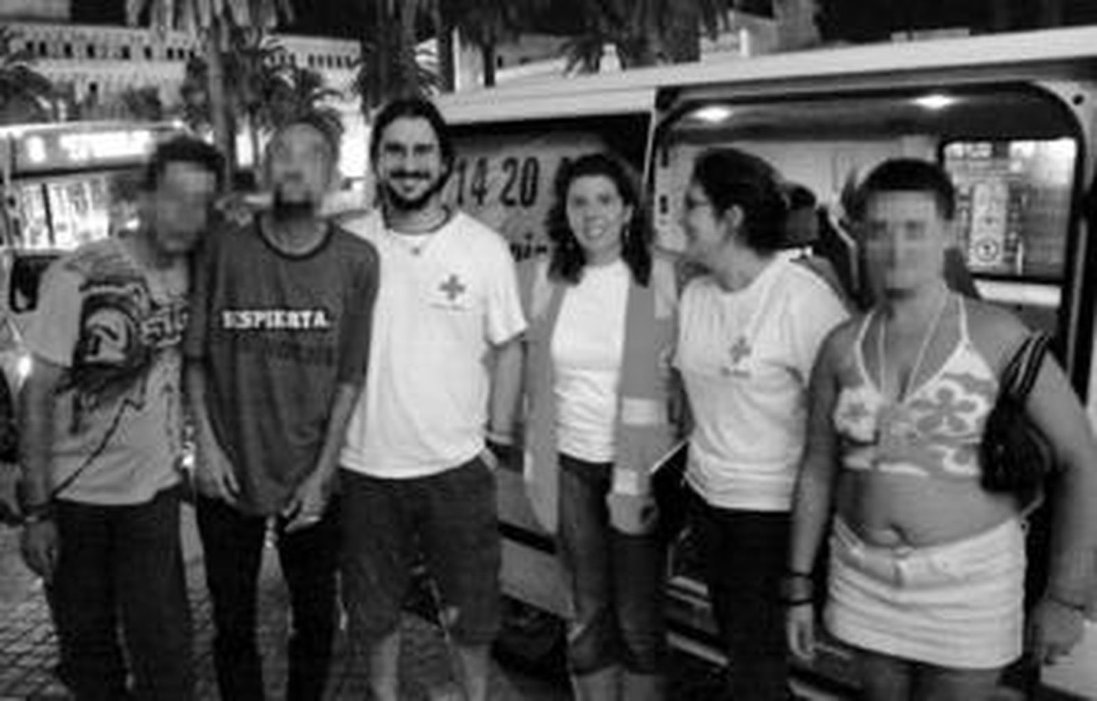 Los voluntarios de la Cruz Roja con algunos de los usuarios el pasado miércoles en la plaza de Las Angustias despúes de darles la cena.