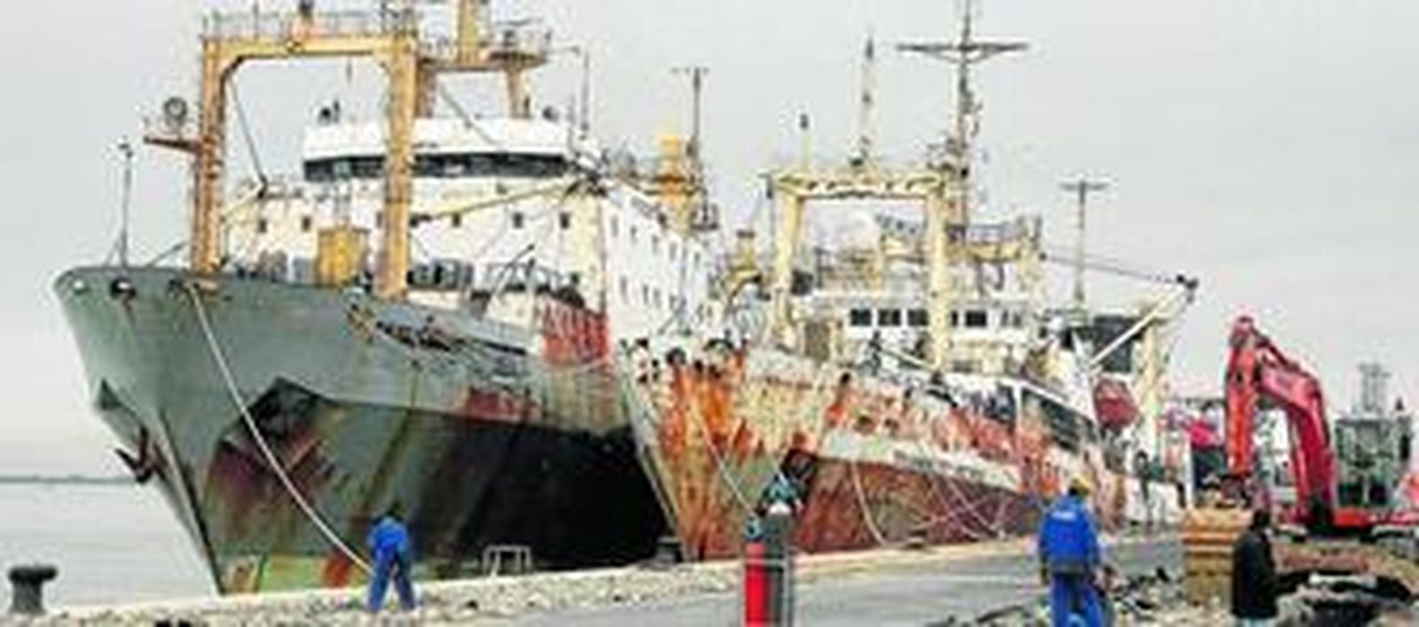 Varios operarios trabajando, ayer, junto a los barcos rusos amarrados en el Puerto onubense.