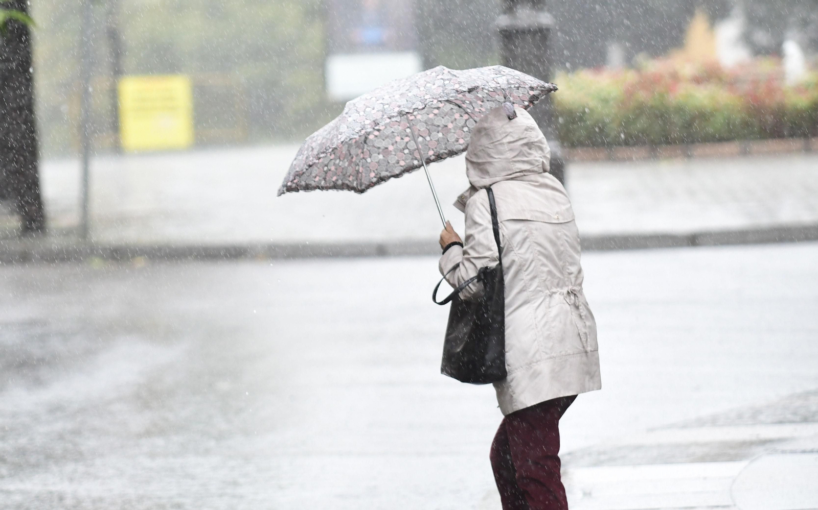 Una mujer se protege de la lluvia.