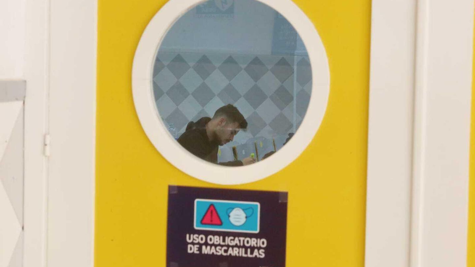 Un joven, en un interior, sin mascarilla.