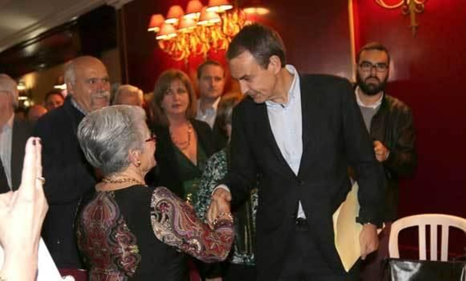 Zapatero saluda a una mujer a su llegada a los salones del Pico de Oro en Chiclana. /Sonia Ramos