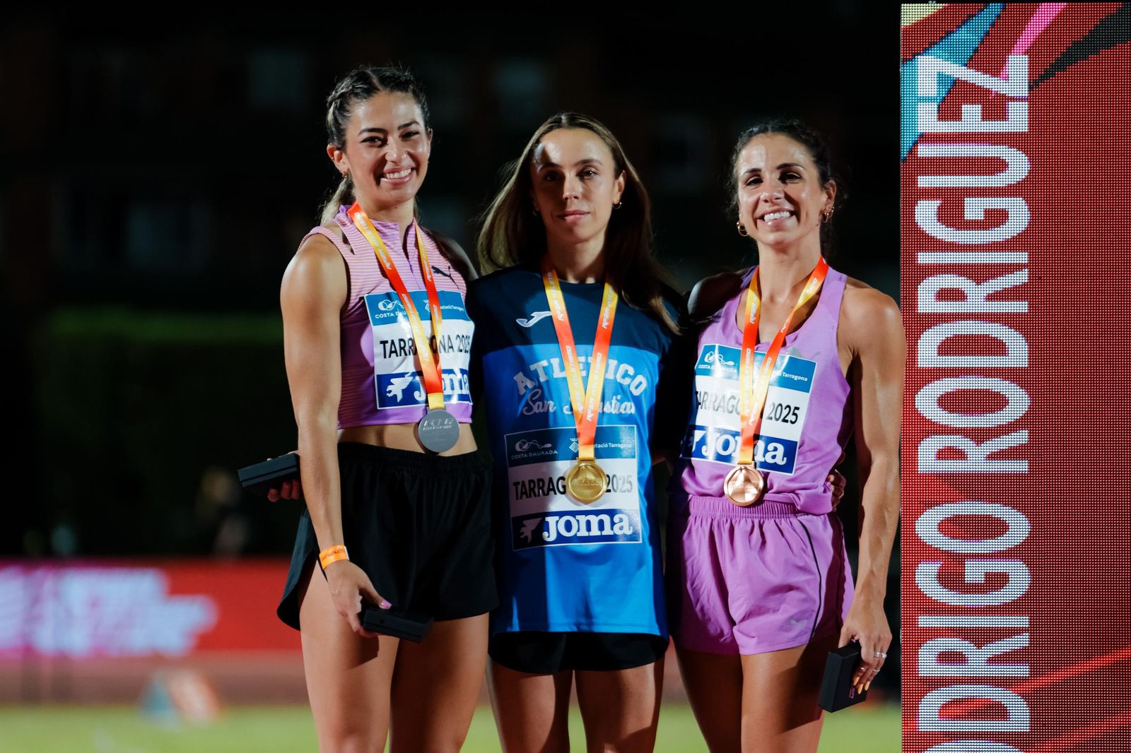 Maribel Pérez, a la derecha de la imagen, sonríe en el podio de Tarragona.