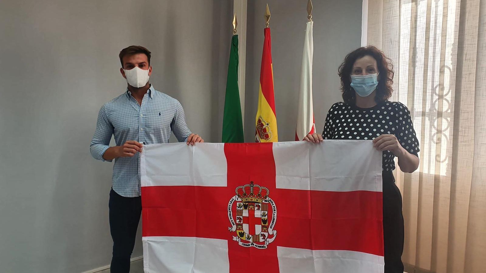El modelo y María Vázquez con la bandera de Almería.