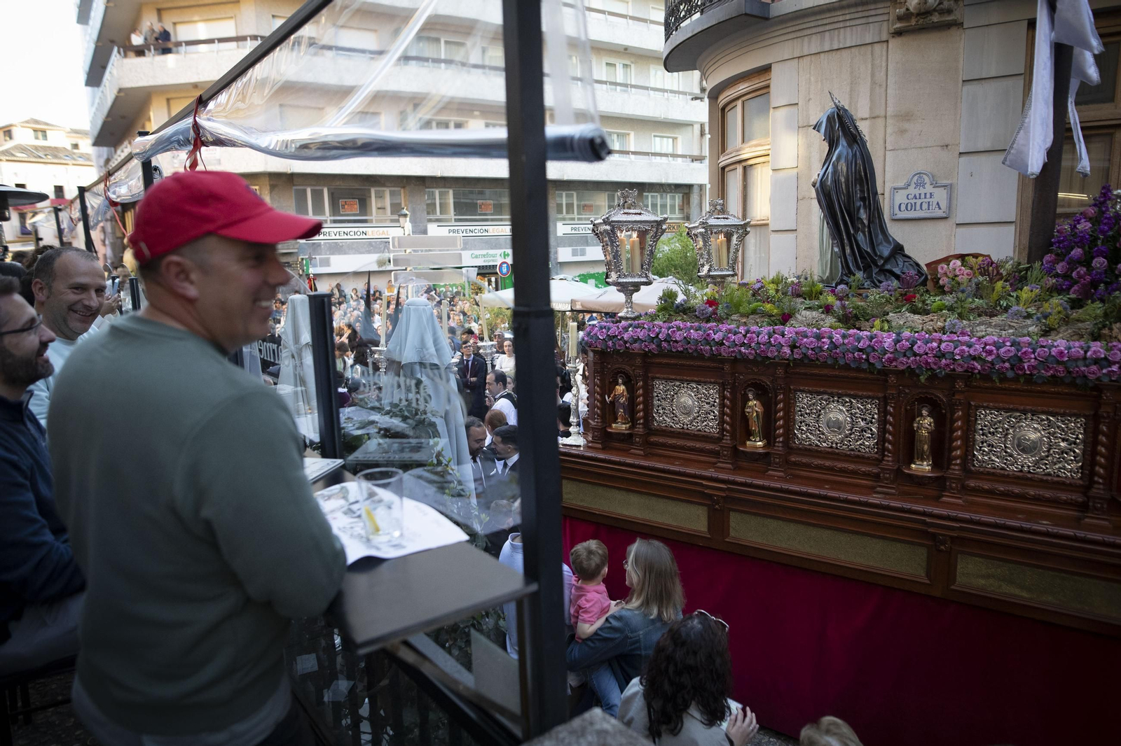 Varias personas disfrutan del paso del Santo Sepulcro desde una terraza. Varias personas disfrutan del paso del Santo Sepulcro desde una terraza.