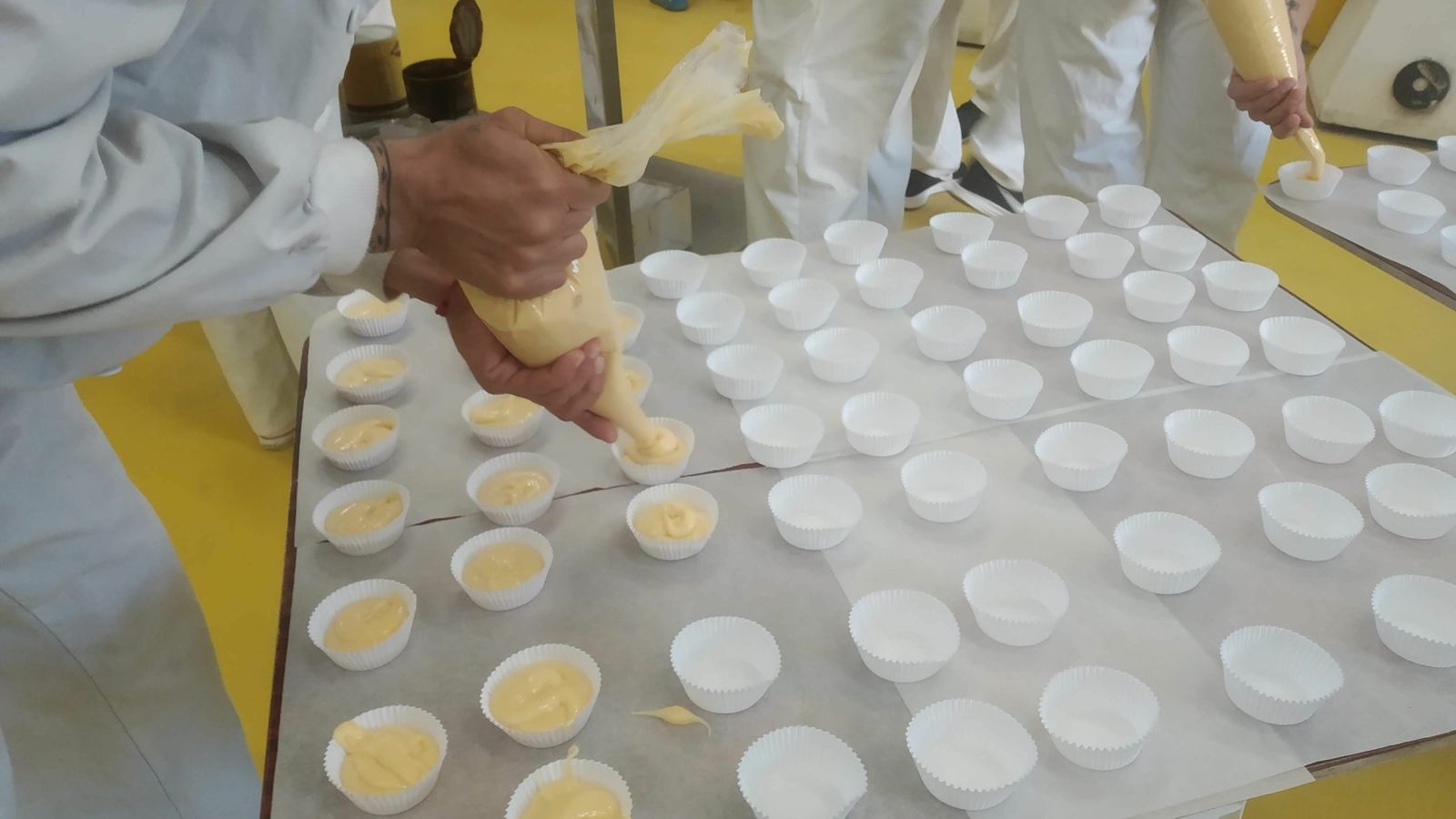 Los internos preparan los moldes con la masa de los muffins.