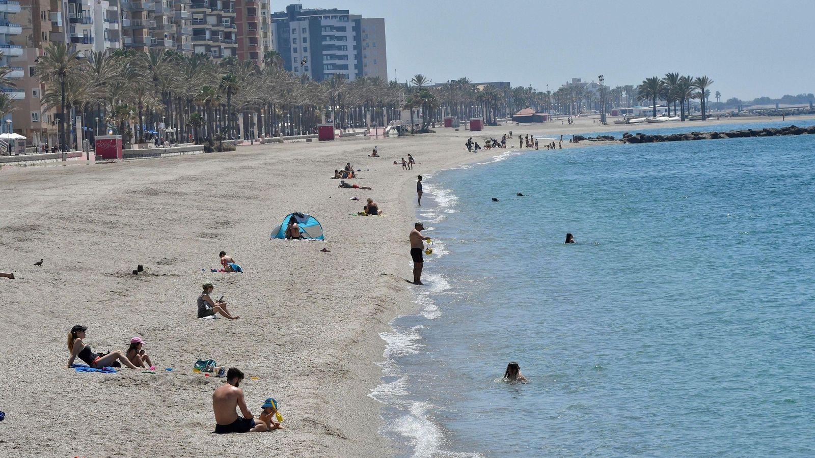 Bañistas que guardan la distancia de seguridad de forma responsable en la playa de Almería