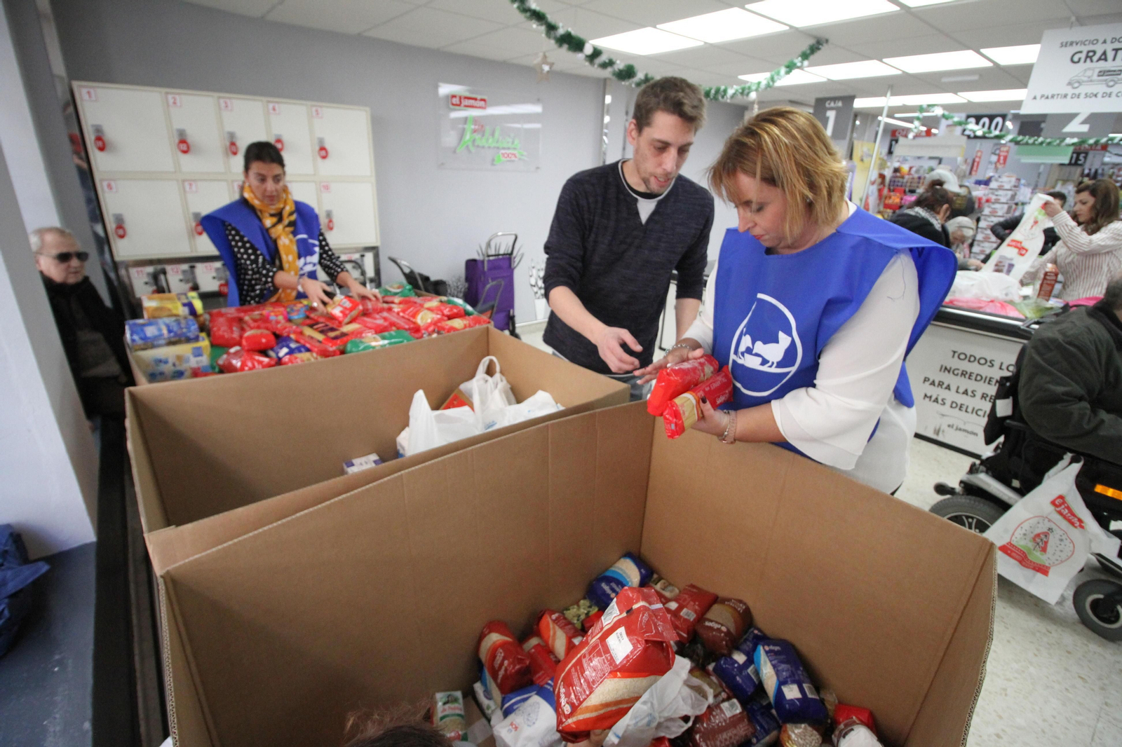 Una voluntaria ordena la donación del cliente de un supermercado.